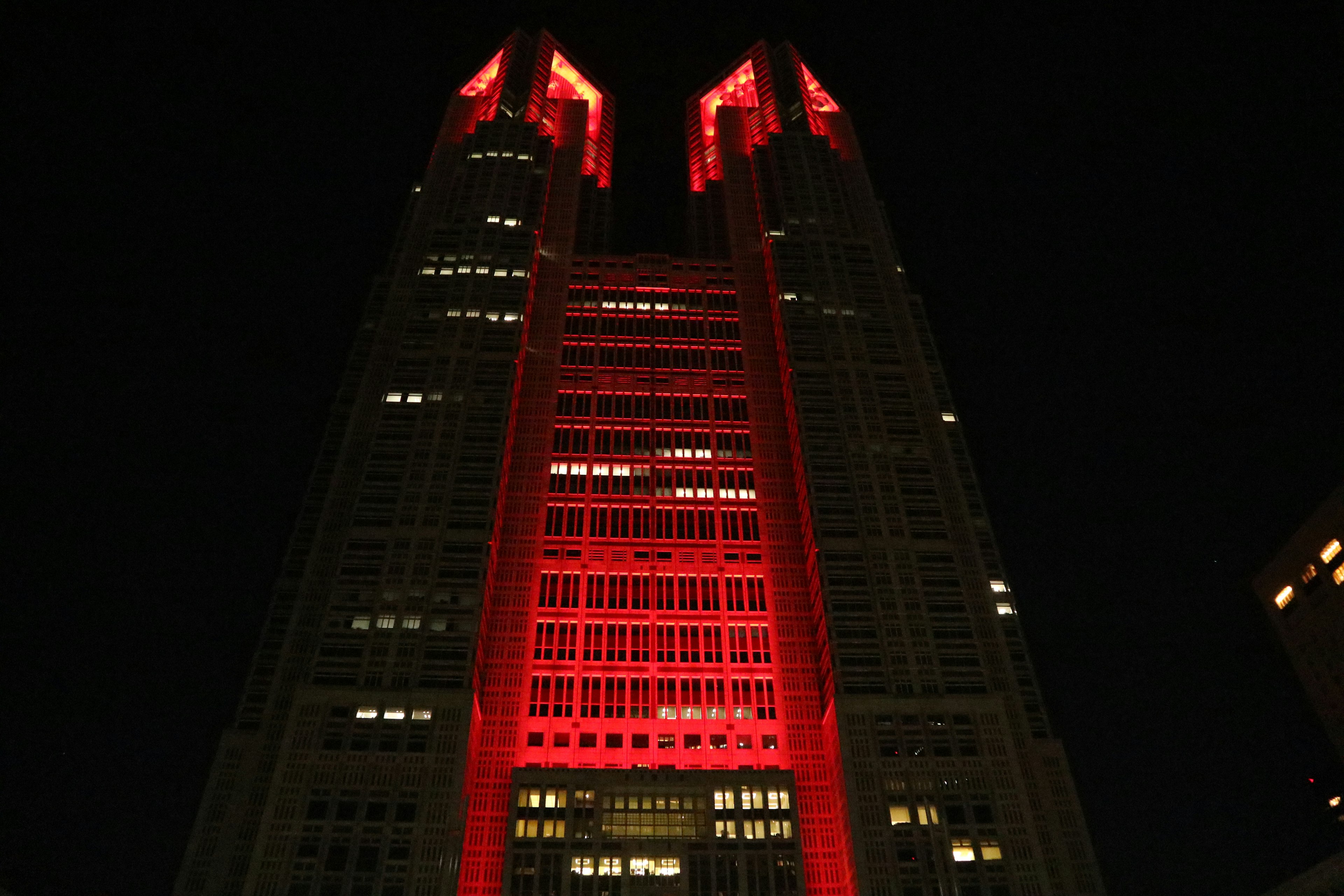 In rotem Licht beleuchteter Wolkenkratzer in Tokio bei Nacht