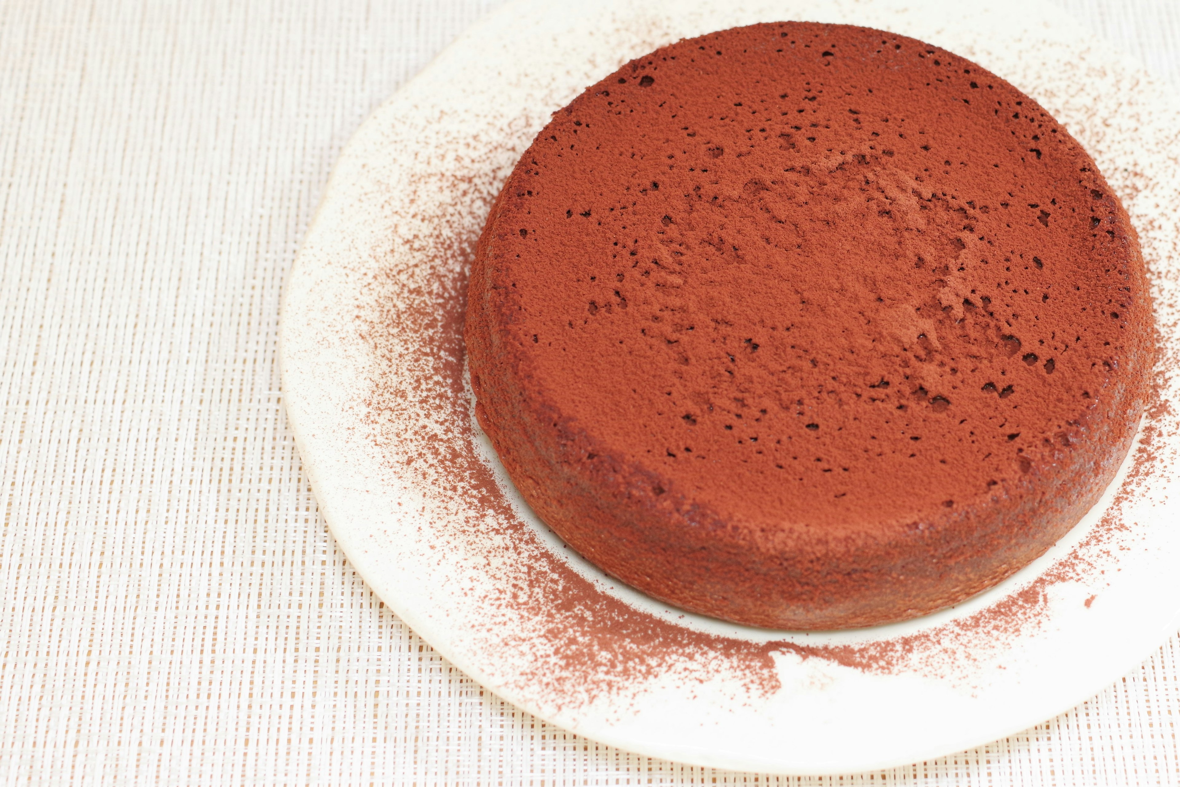 A simple chocolate cake dusted with cocoa powder