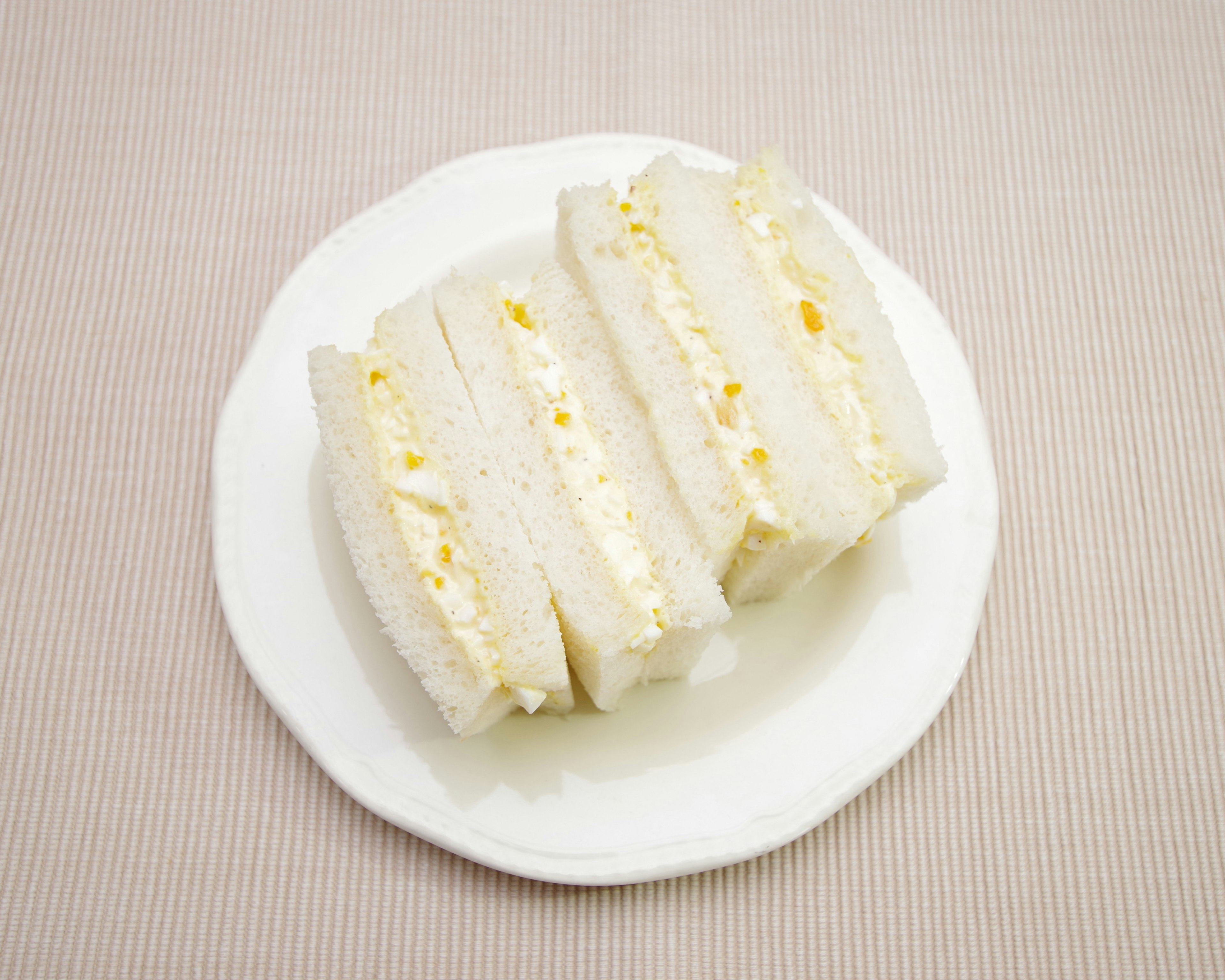 Sándwich de huevo en rodajas en un plato blanco