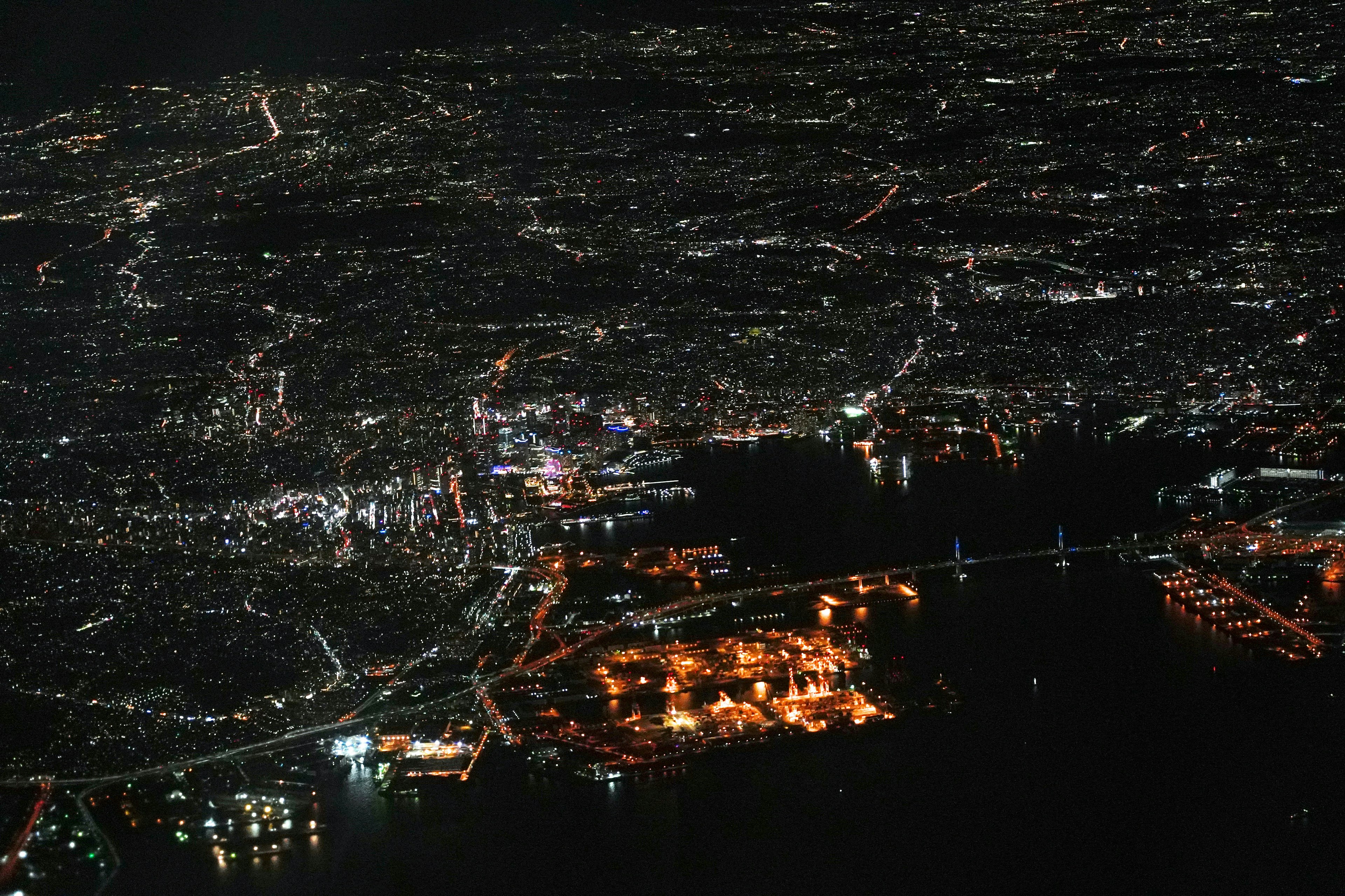 Vista aérea de una ciudad por la noche Luces brillantes iluminando el paisaje urbano y el puerto