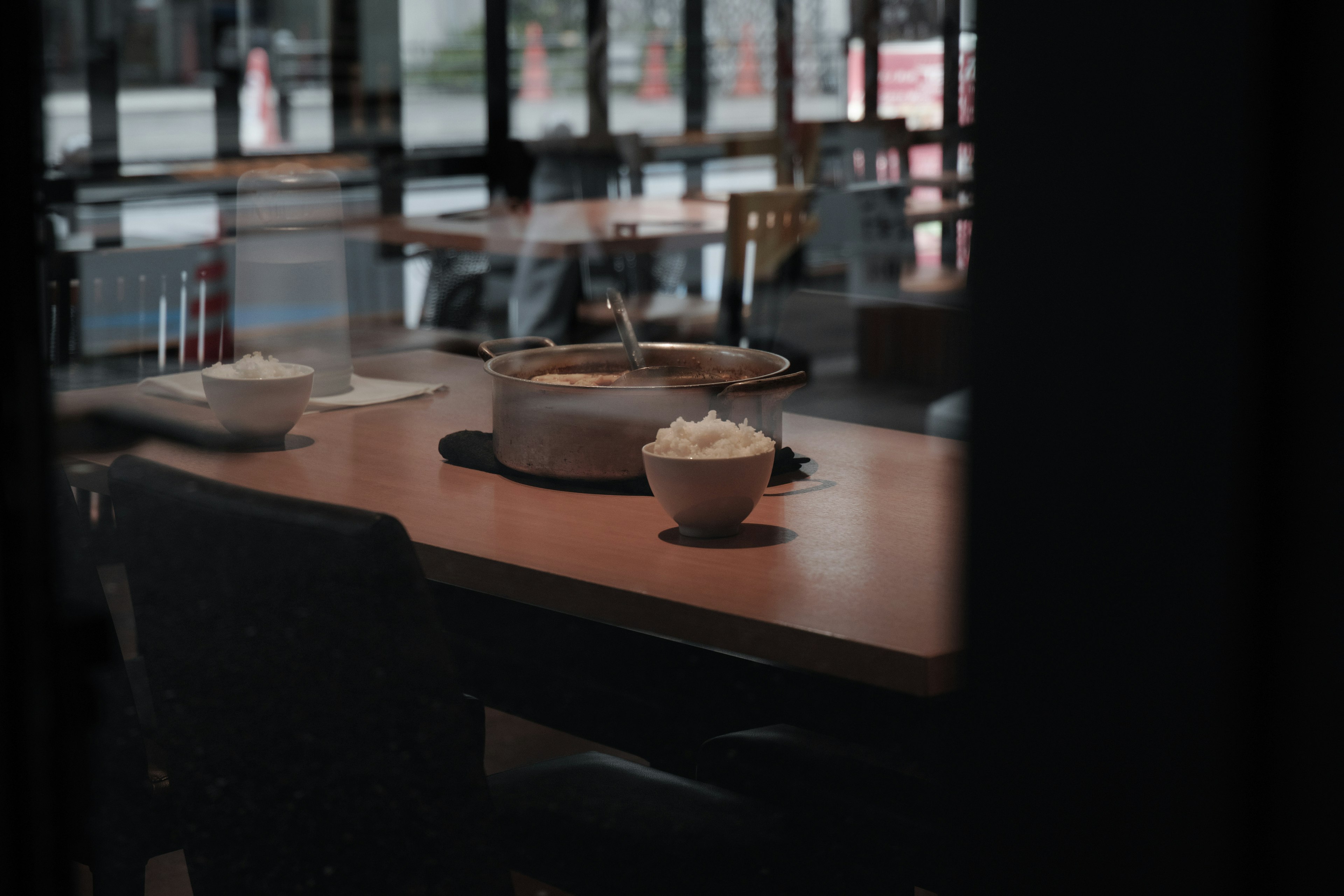 Interior of a restaurant with a pot and bowls of rice on the table