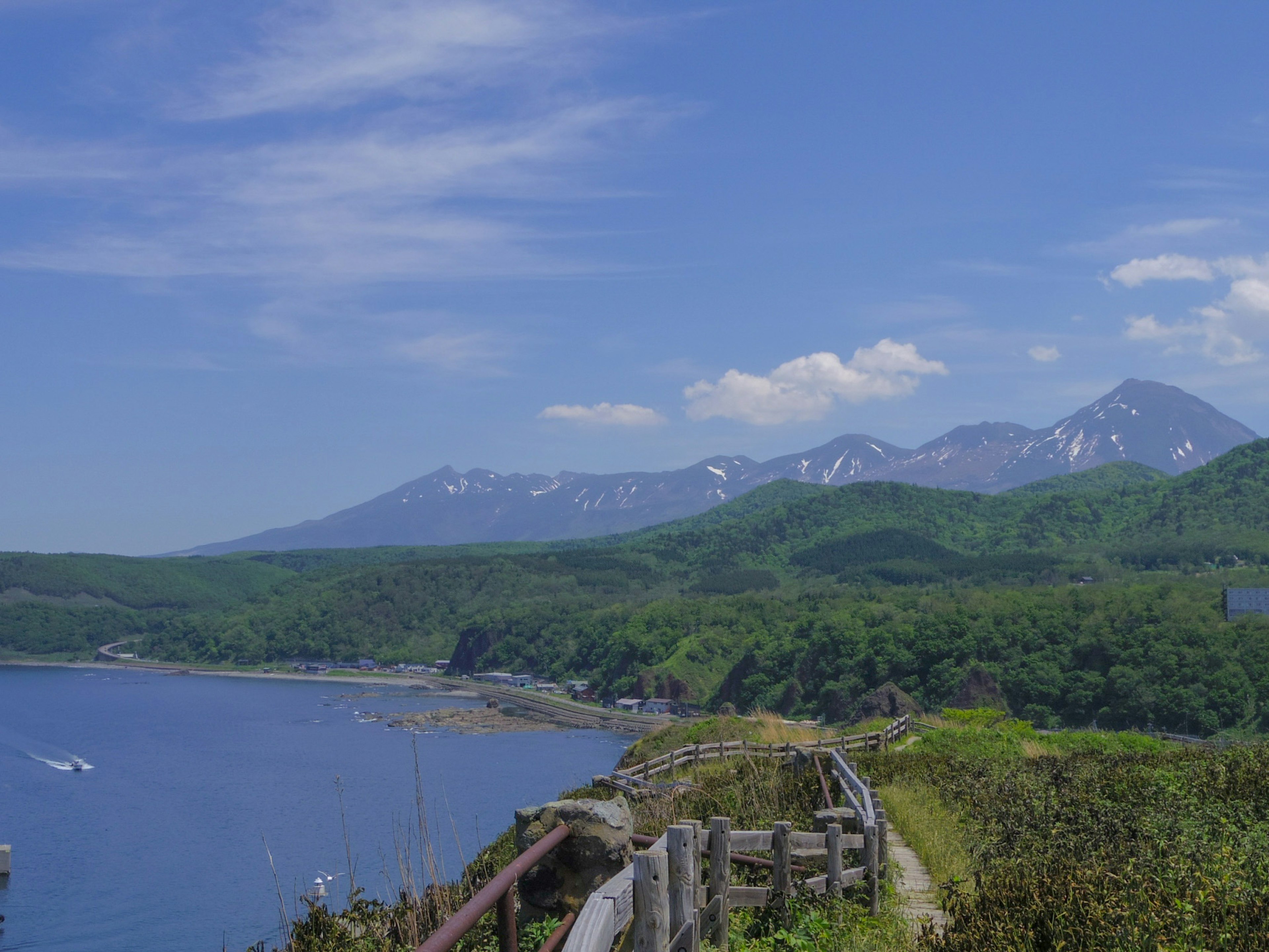 Paesaggio costiero con cielo blu e montagne verdi