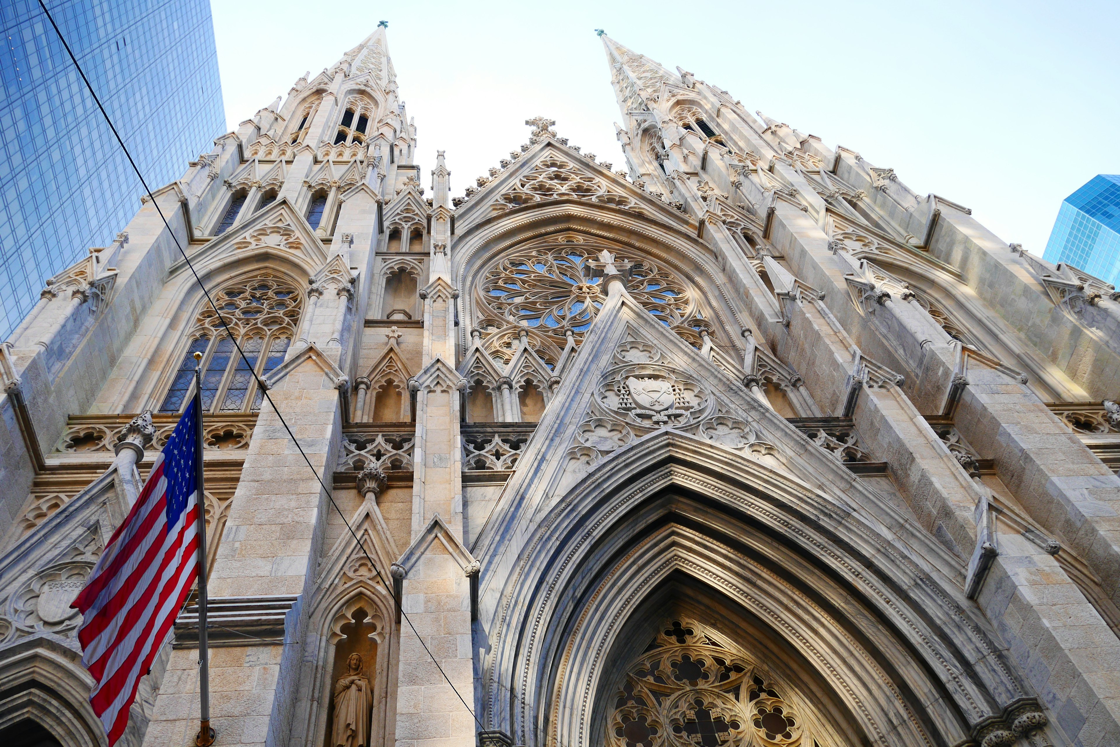 Gothic cathedral exterior viewed from below with American flag