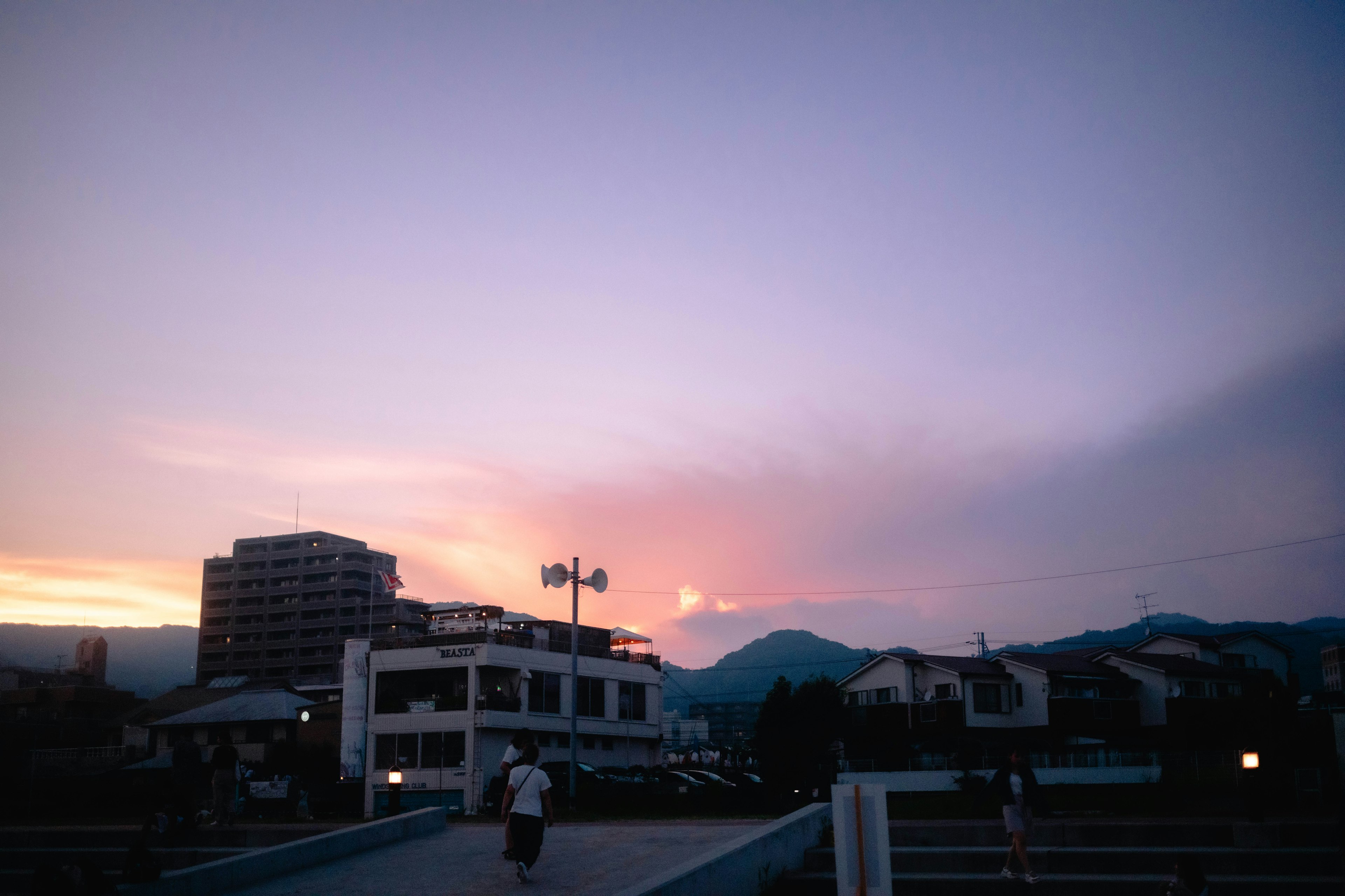 Edifici e montagne silhouettati durante un tramonto colorato