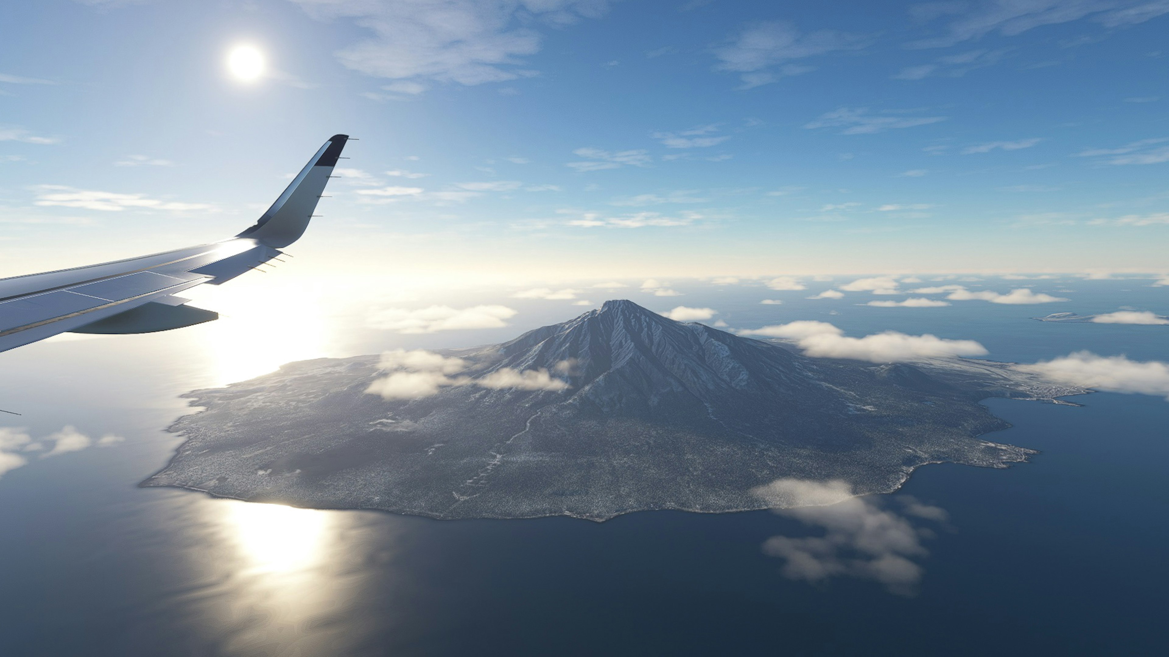 Aerial view of a mountain island with an airplane wing