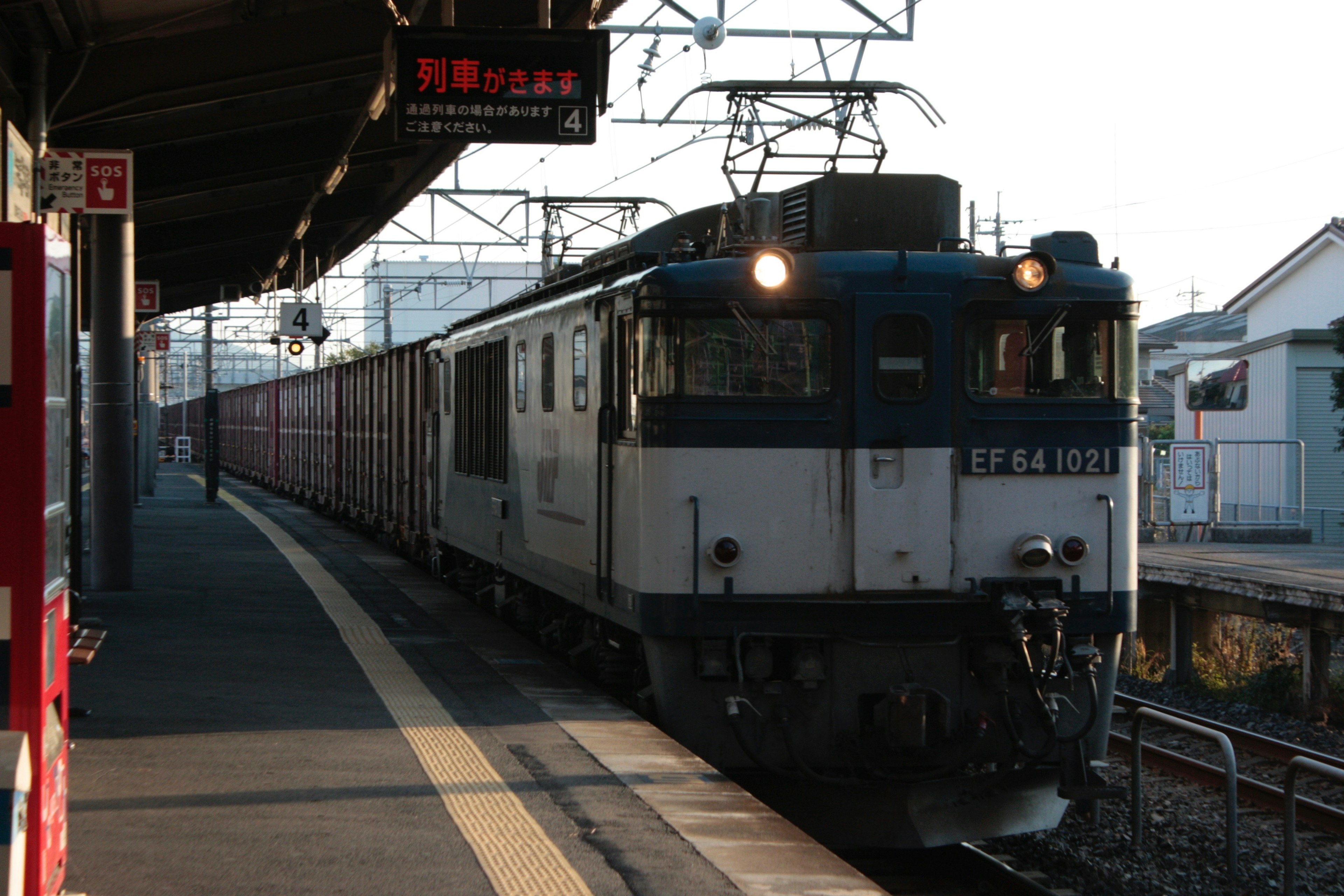 貨物列車が駅に停車中で夕暮れの光が当たるシーン