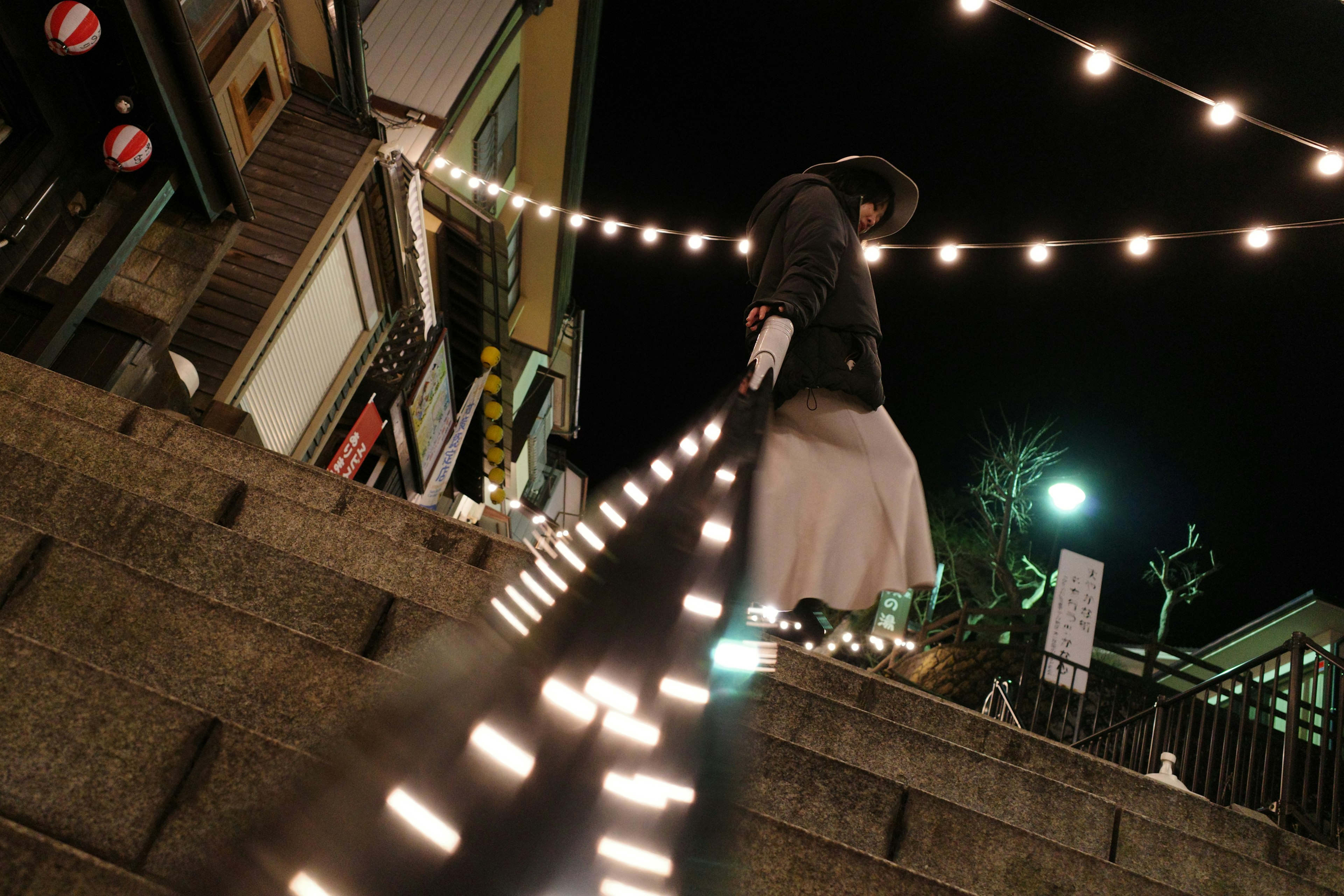 Persona descendiendo escaleras por la noche con luces brillantes