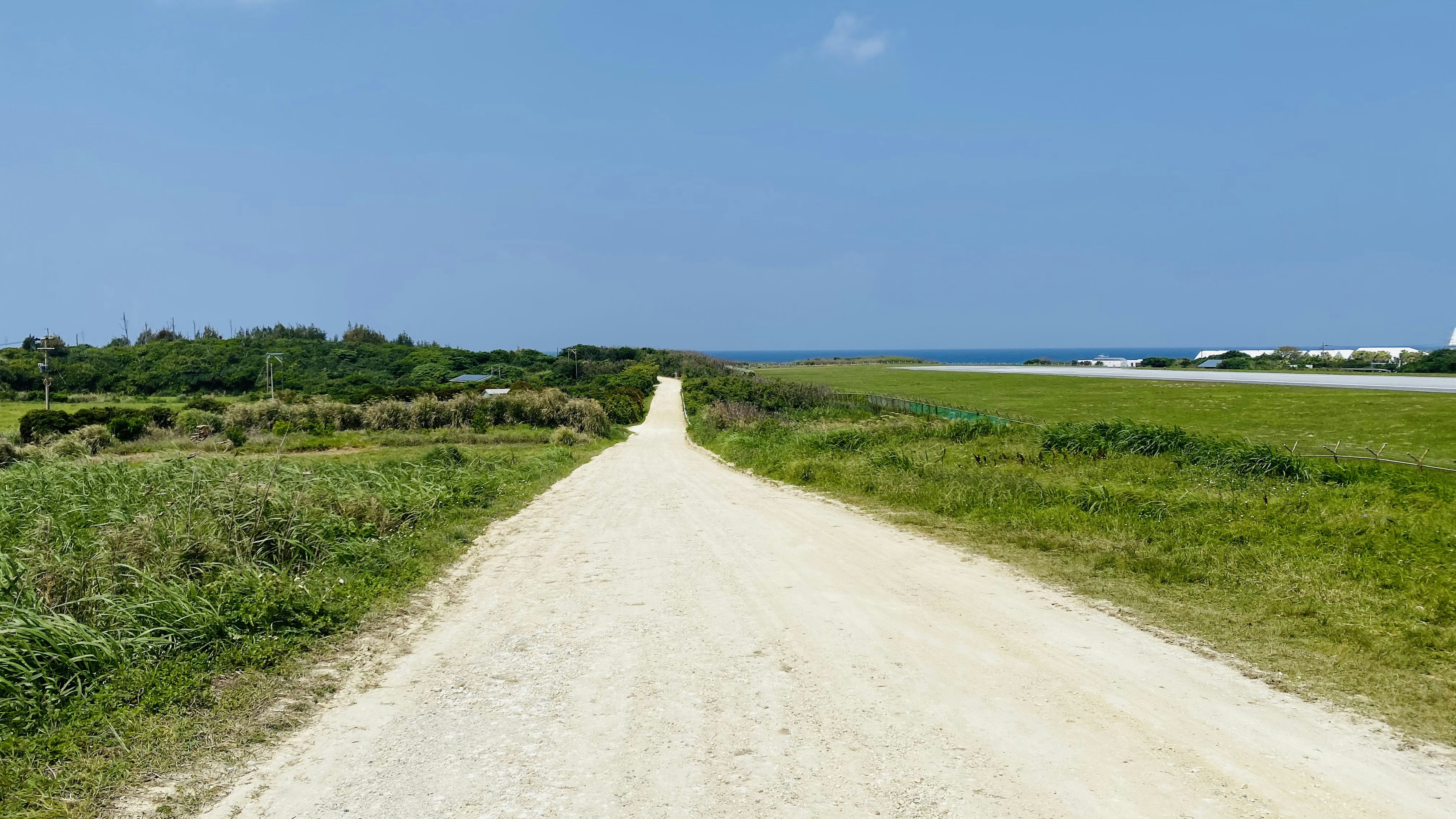 Schotterweg, der zum Meer unter einem klaren blauen Himmel führt