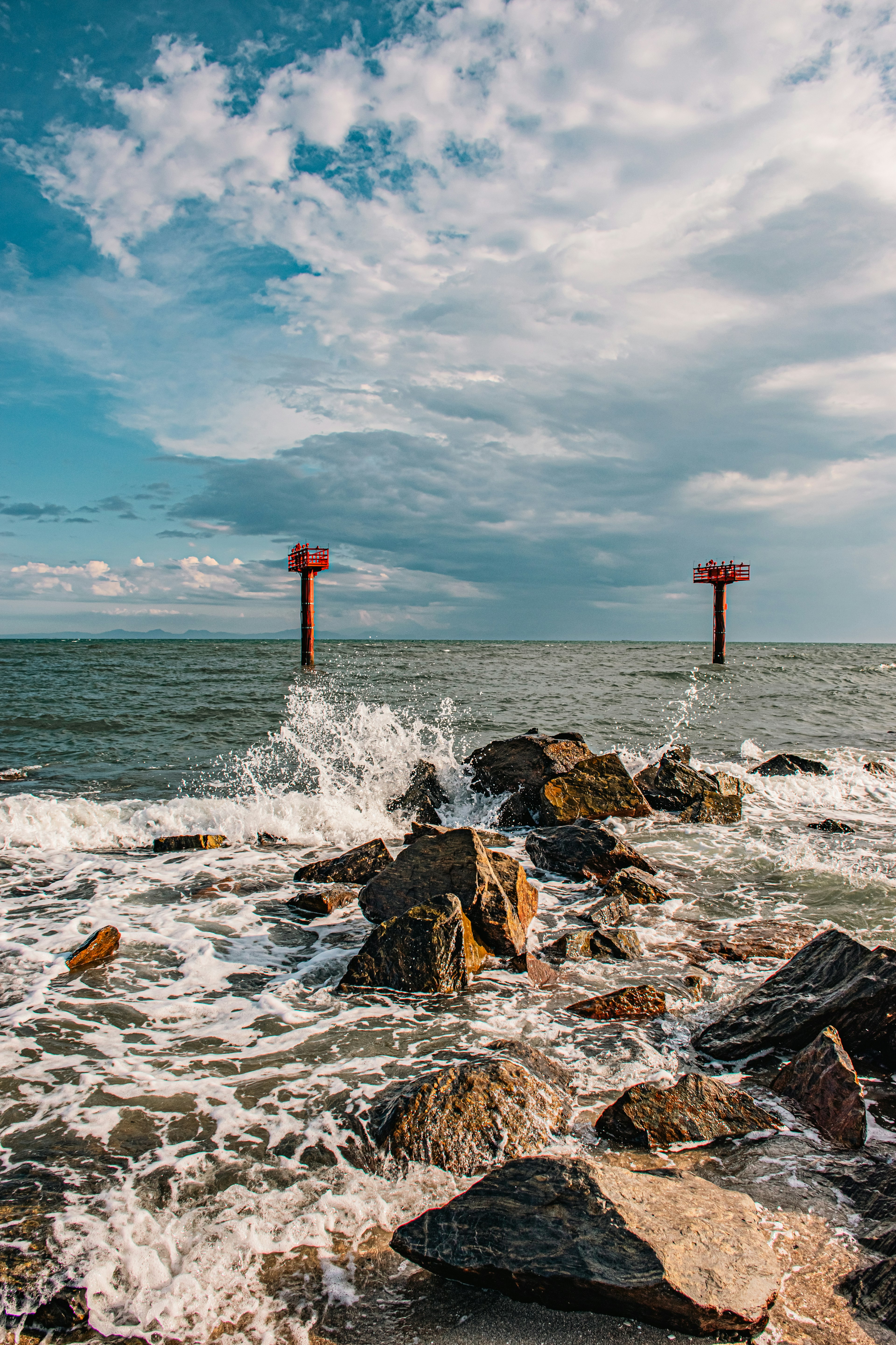 Côte avec des rochers et des vagues marques rouges dans la mer ciel bleu