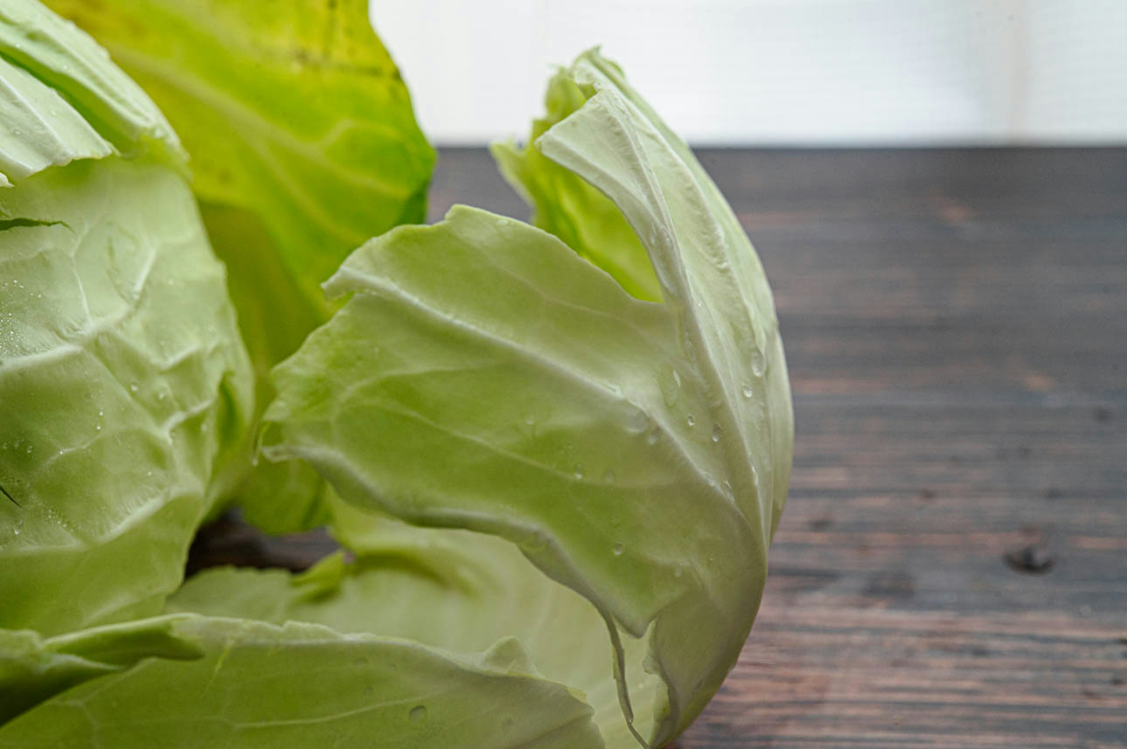 Feuilles de chou frais reposant sur une table en bois