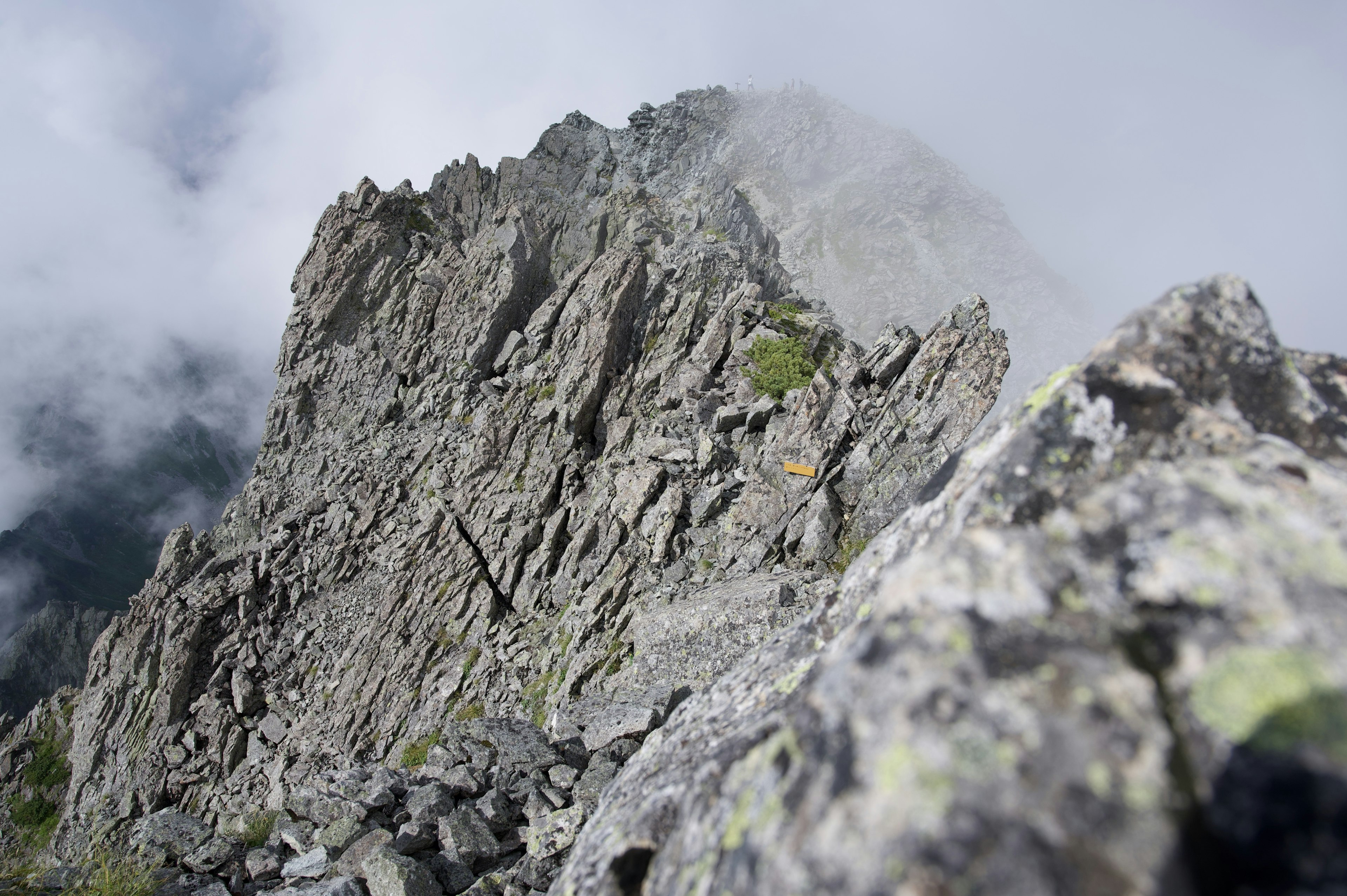 Close-up of rugged mountain rock face shrouded in mist