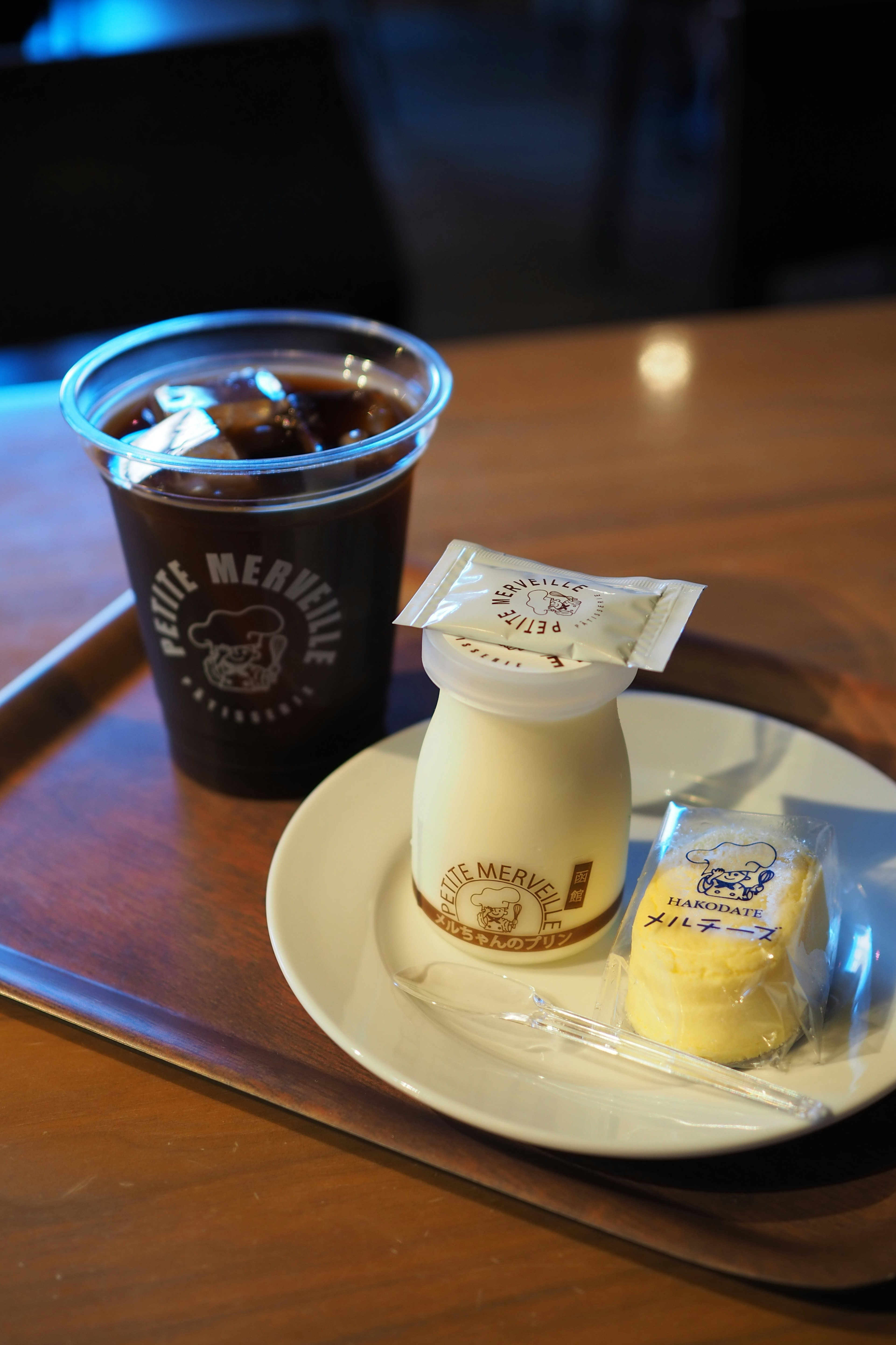 A scene featuring iced coffee and dessert on a cafe tray