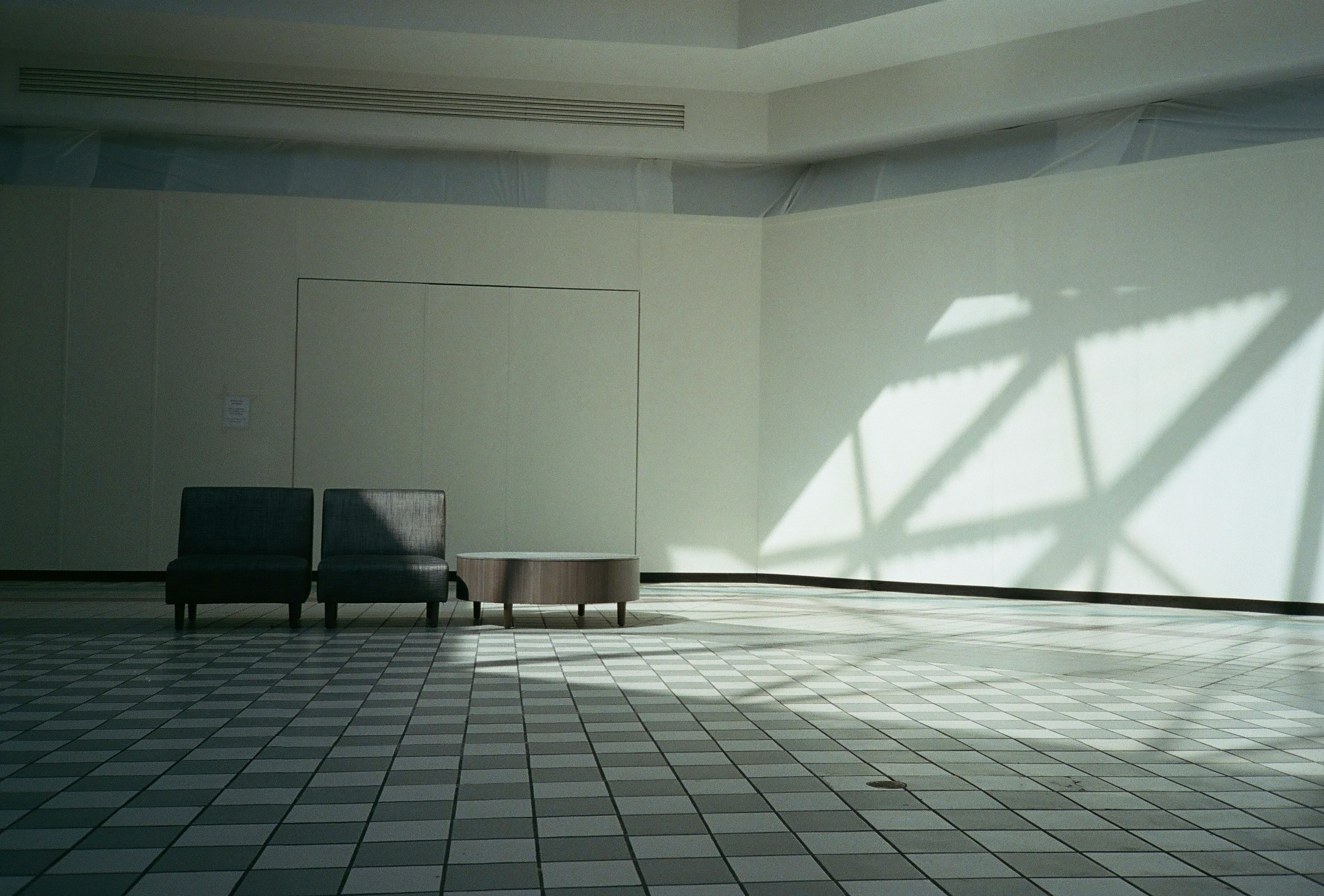 Geräumiger Raum mit zwei Stühlen und einem Tisch, der schöne Schatten wirft