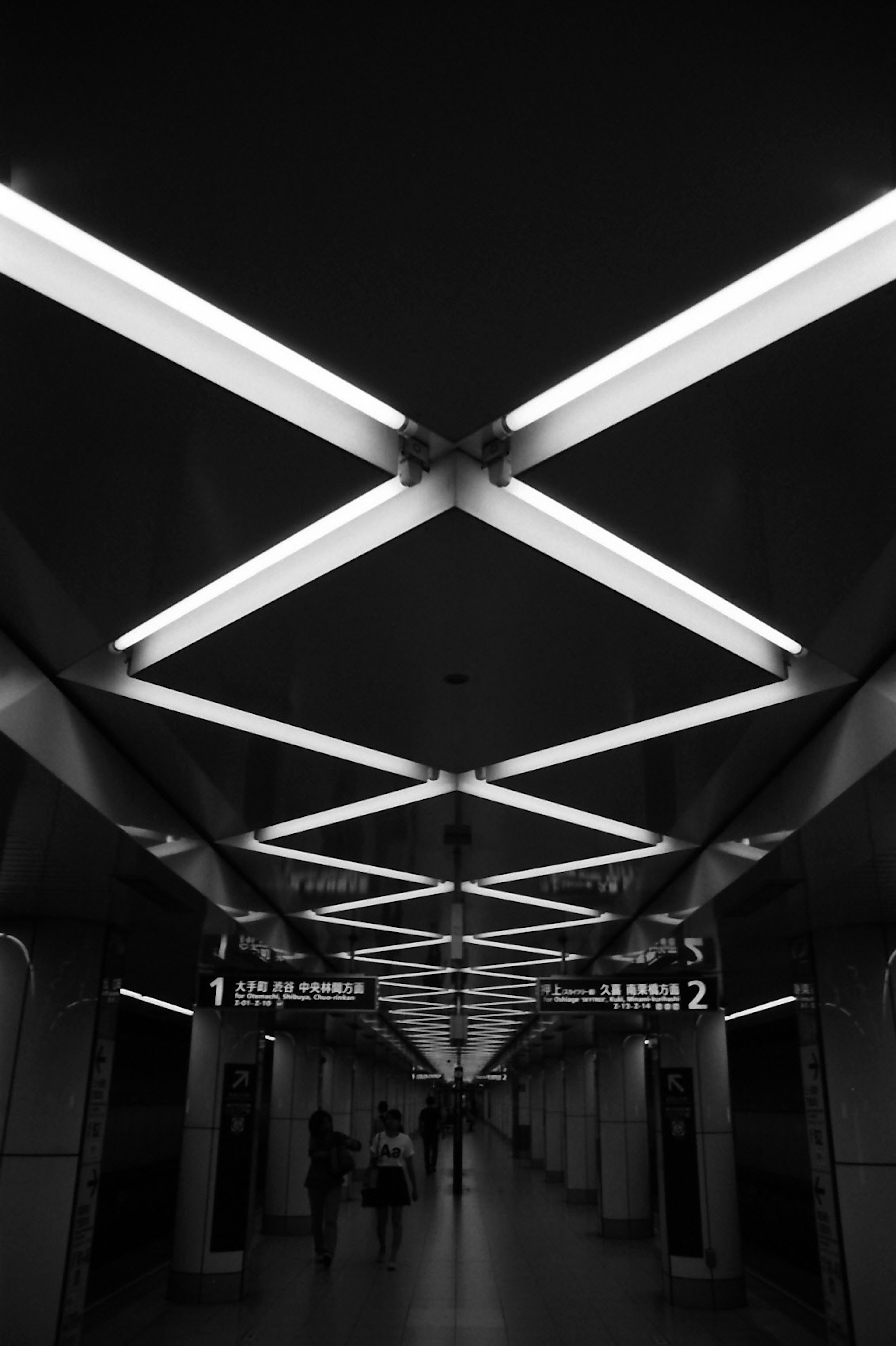 Foto in bianco e nero di una stazione della metropolitana con luci incrociate