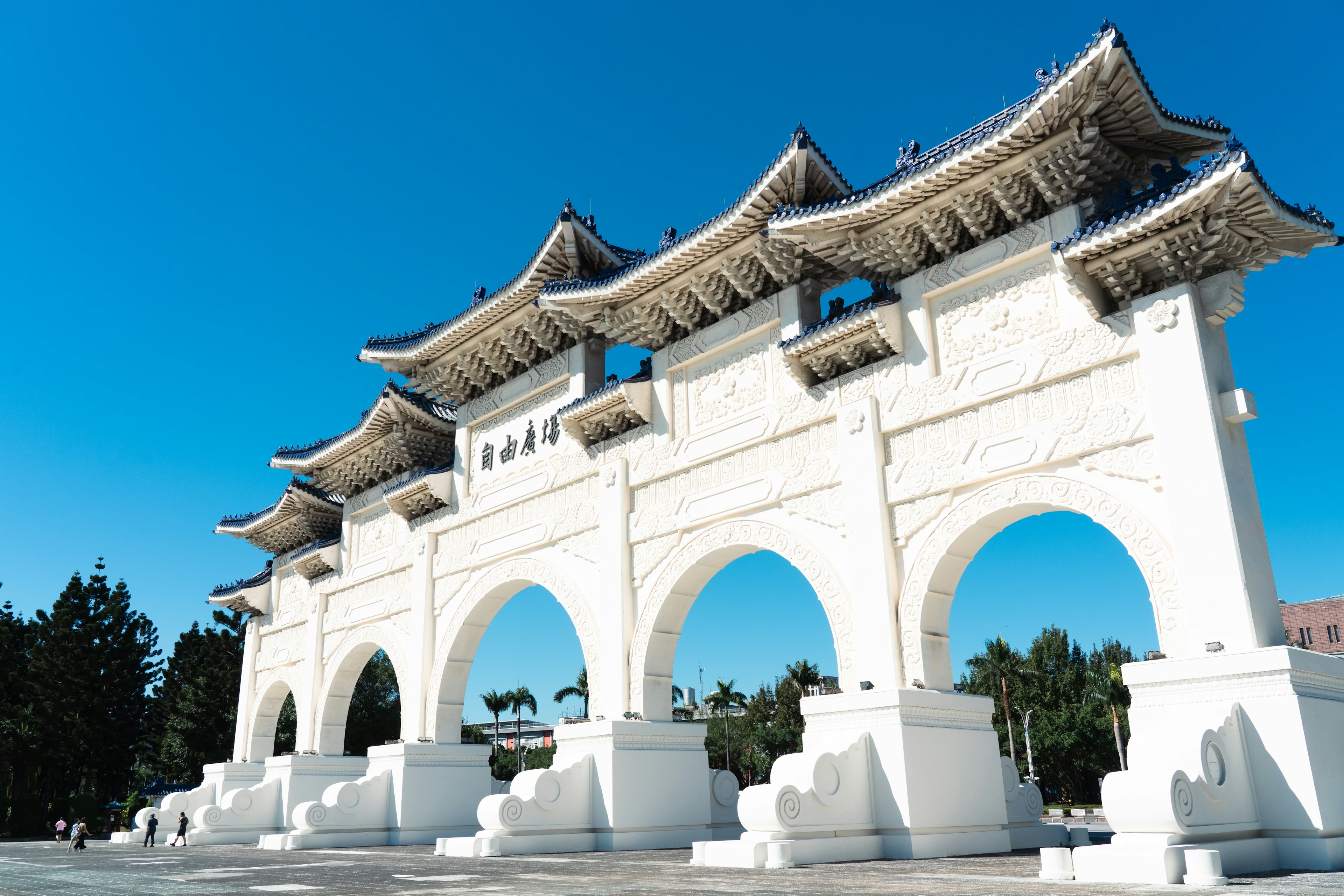 Arco bianco con tetto tradizionale sotto un cielo blu chiaro