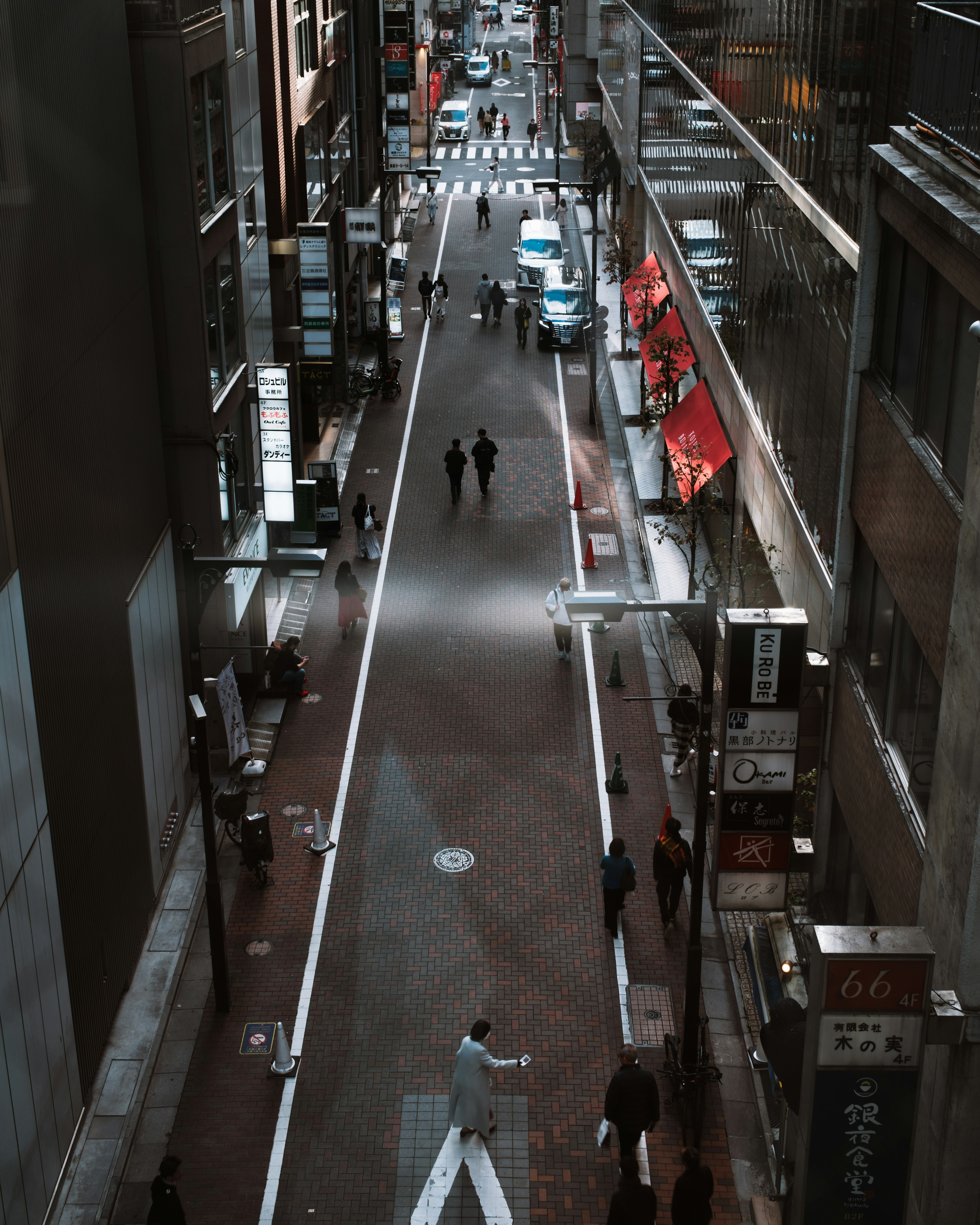 Rue étroite avec des gens marchant et des bâtiments de chaque côté