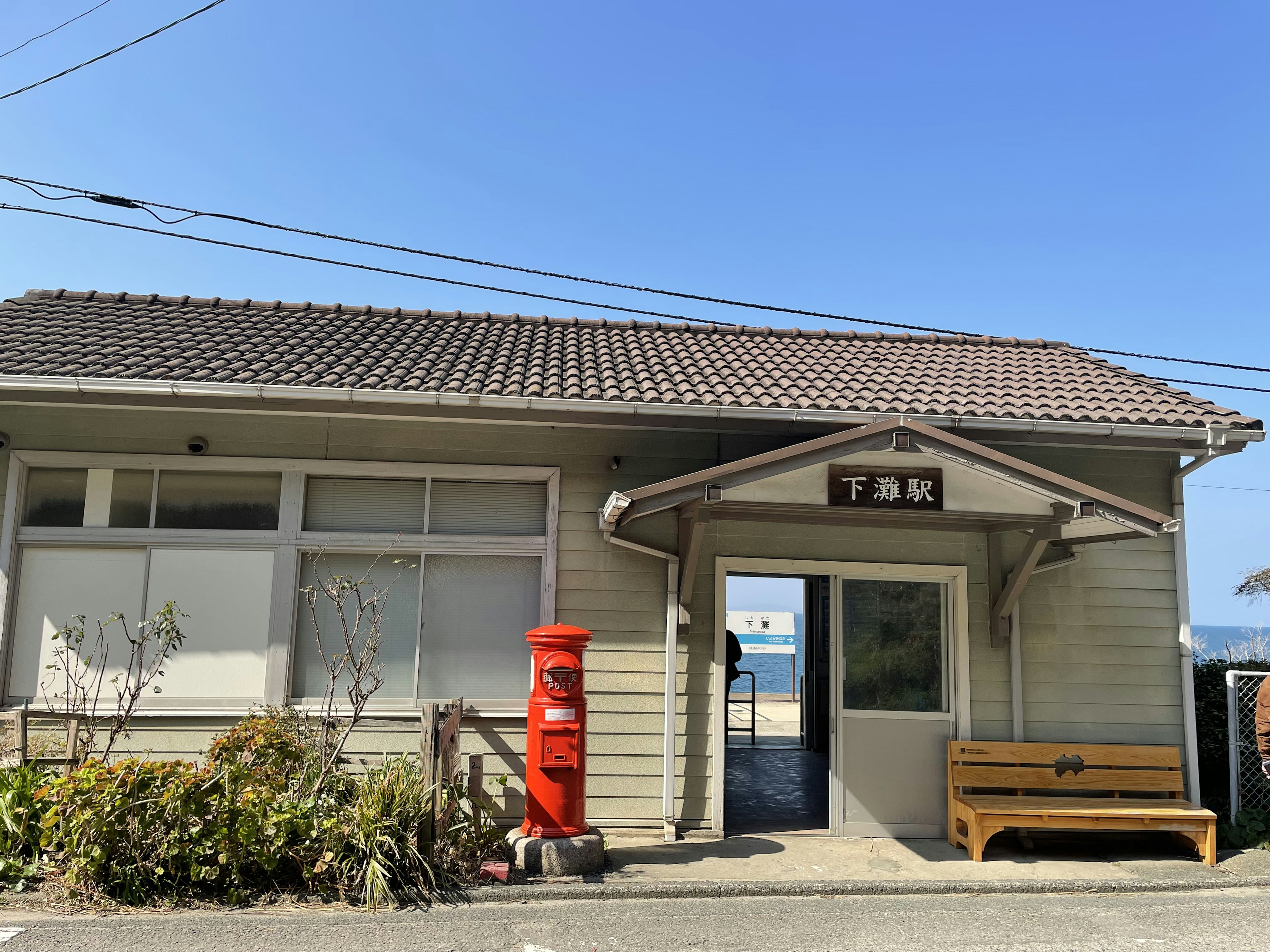 Une petite gare avec une boîte aux lettres rouge devant