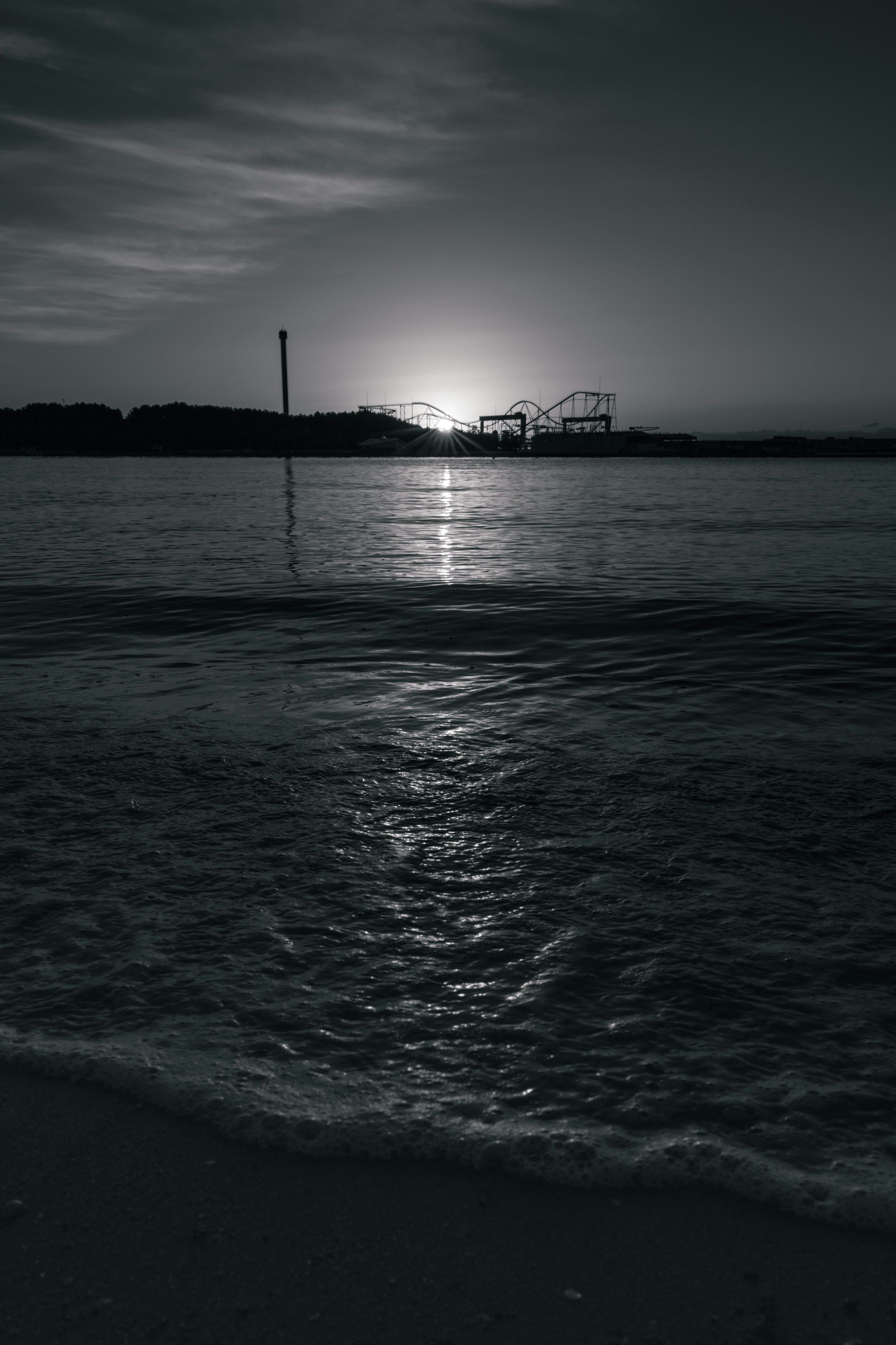 Paysage côtier en noir et blanc coucher de soleil se reflétant sur l'eau