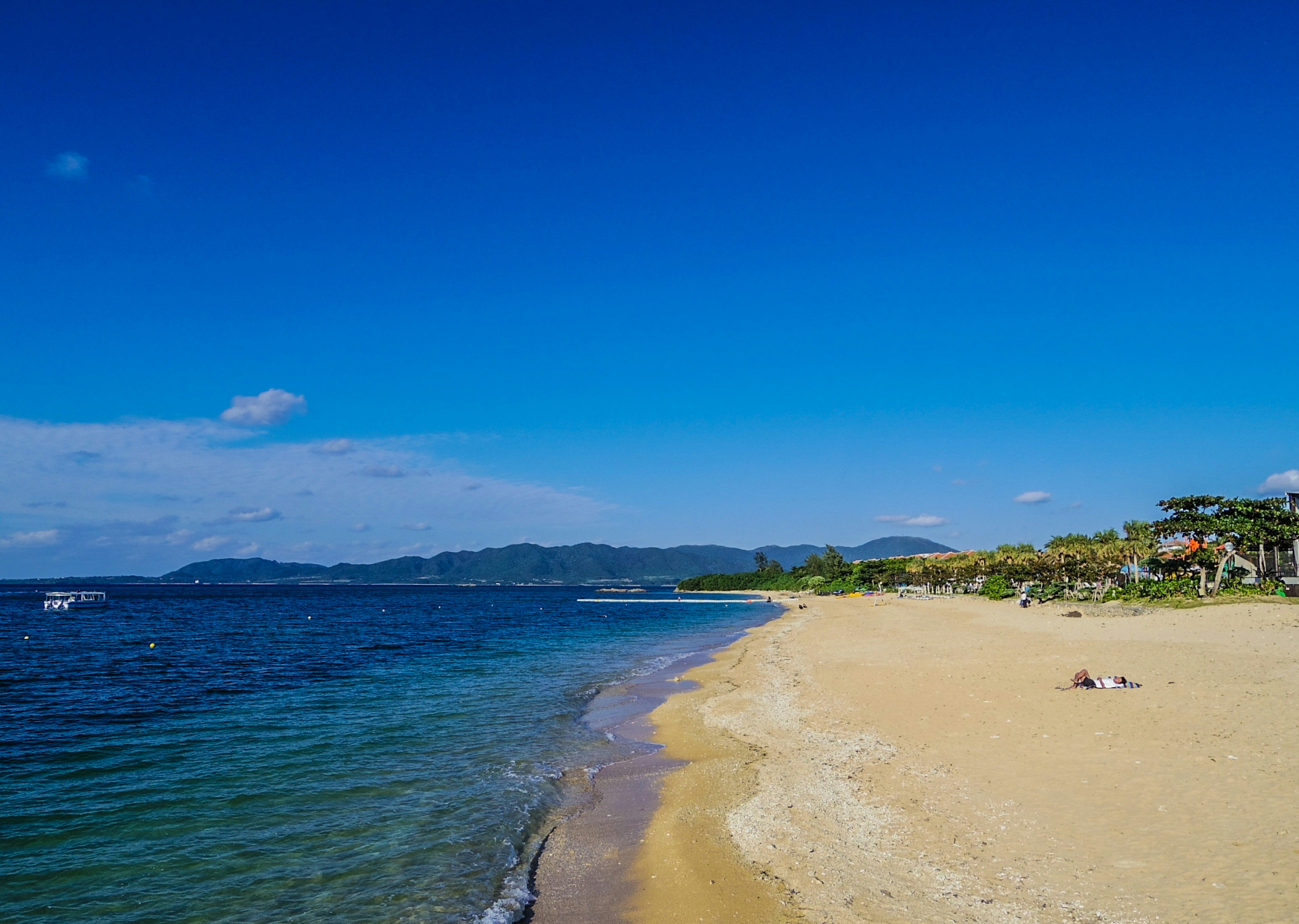 ทิวทัศน์ชายหาดที่มีท้องฟ้าสีฟ้าและทะเลสงบ