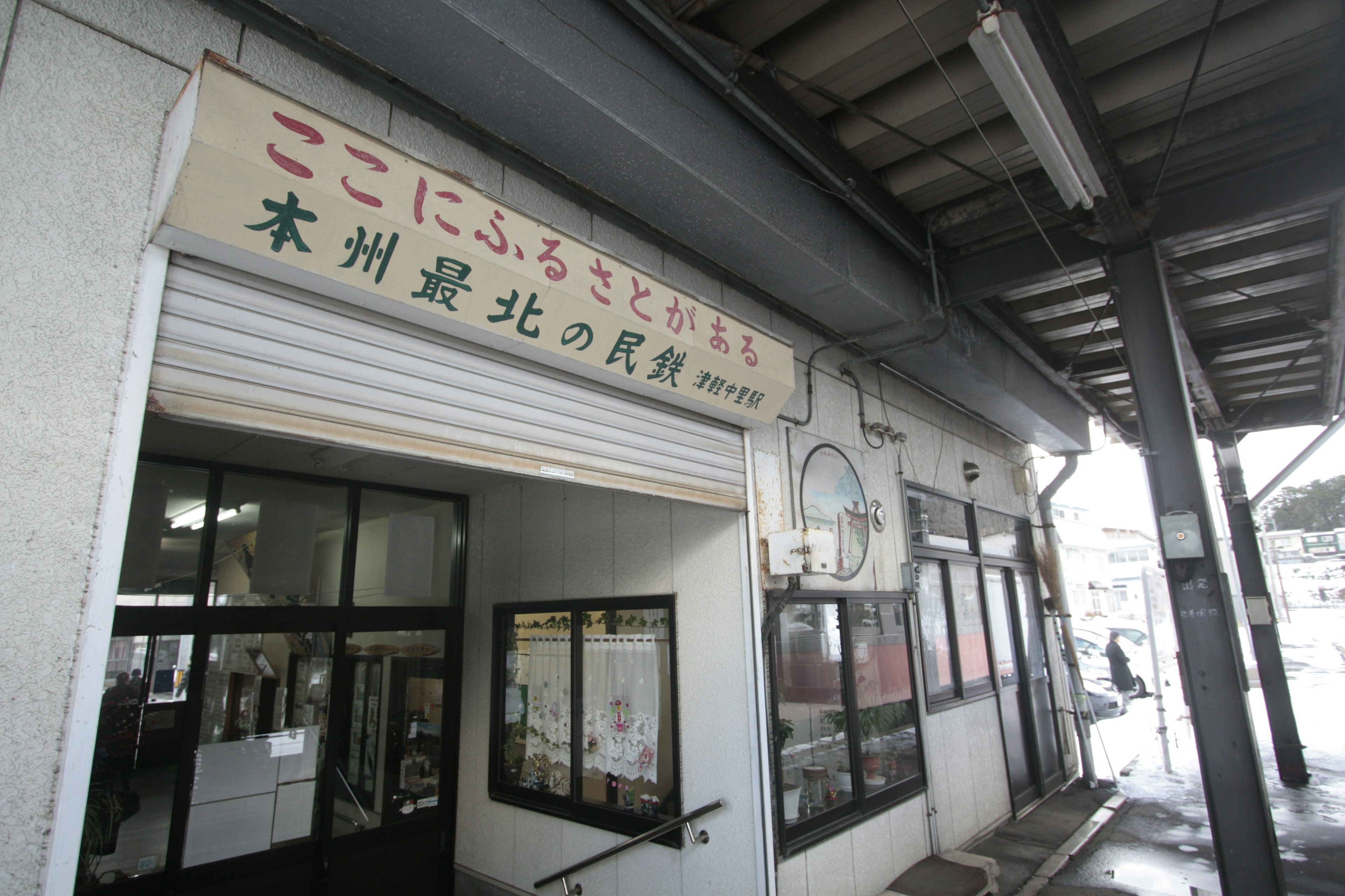 Building entrance with a sign and windows at a train station