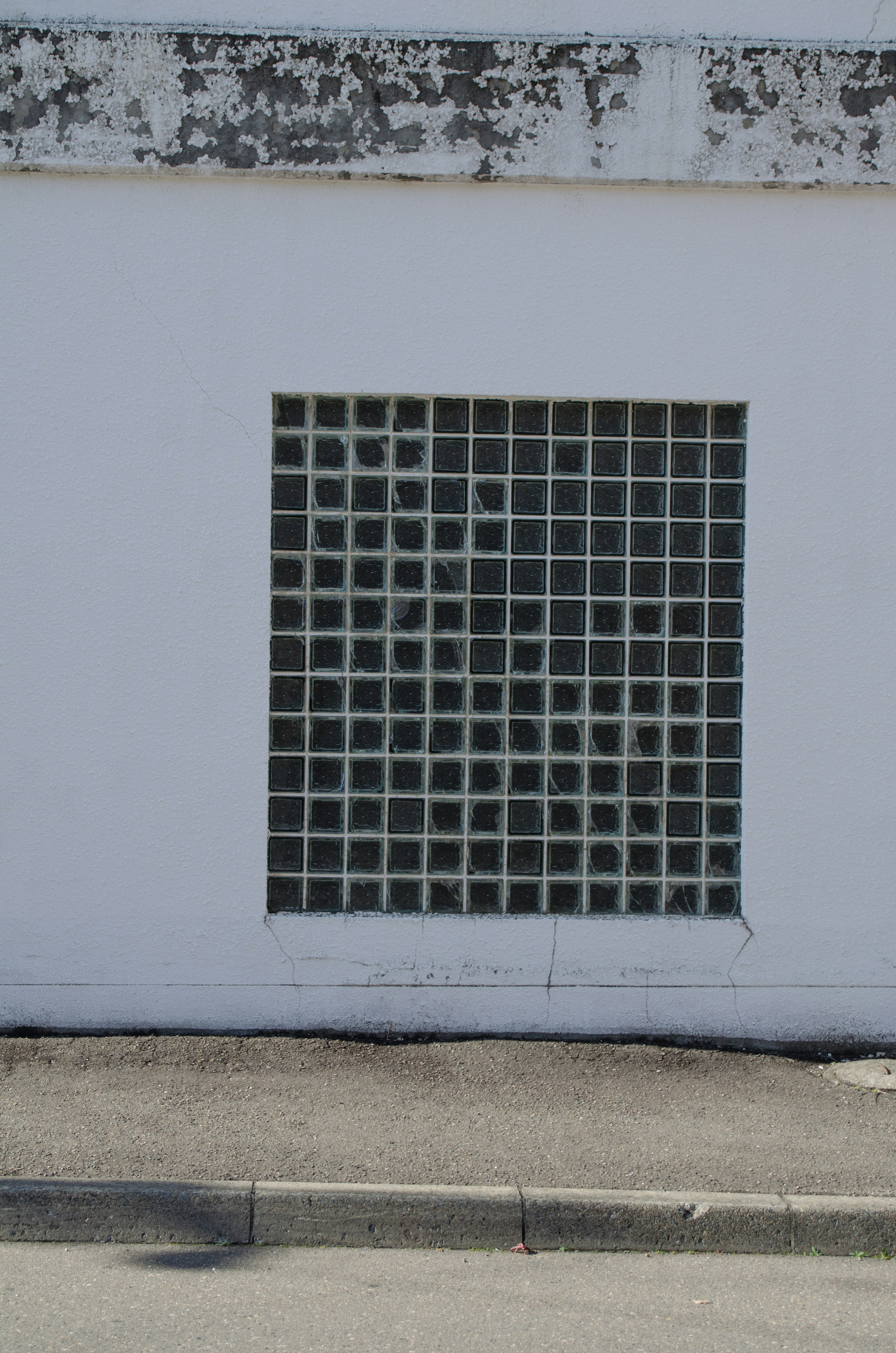 Un mur blanc avec une grille de blocs de verre