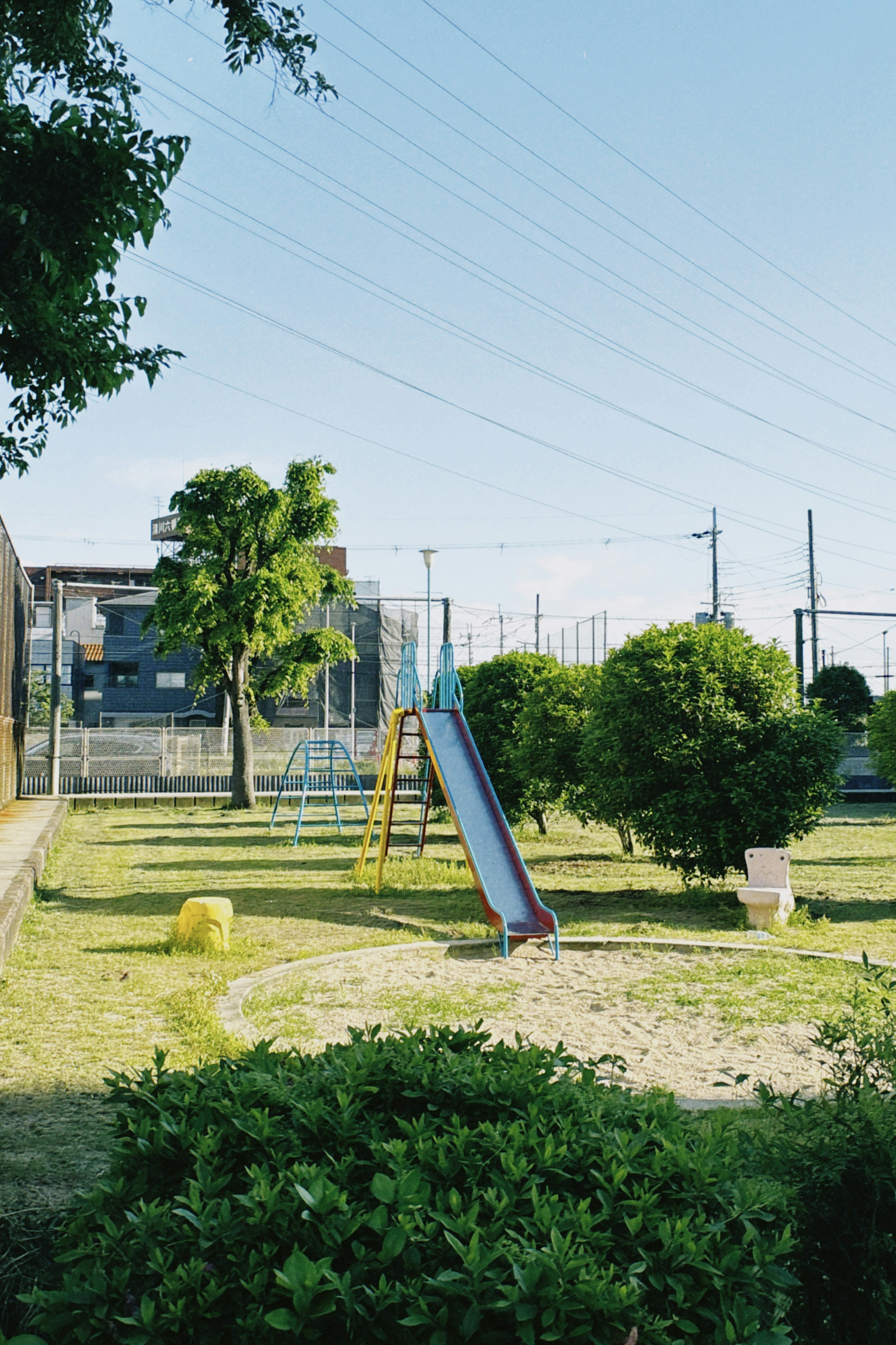 Park scene featuring a slide and swing set