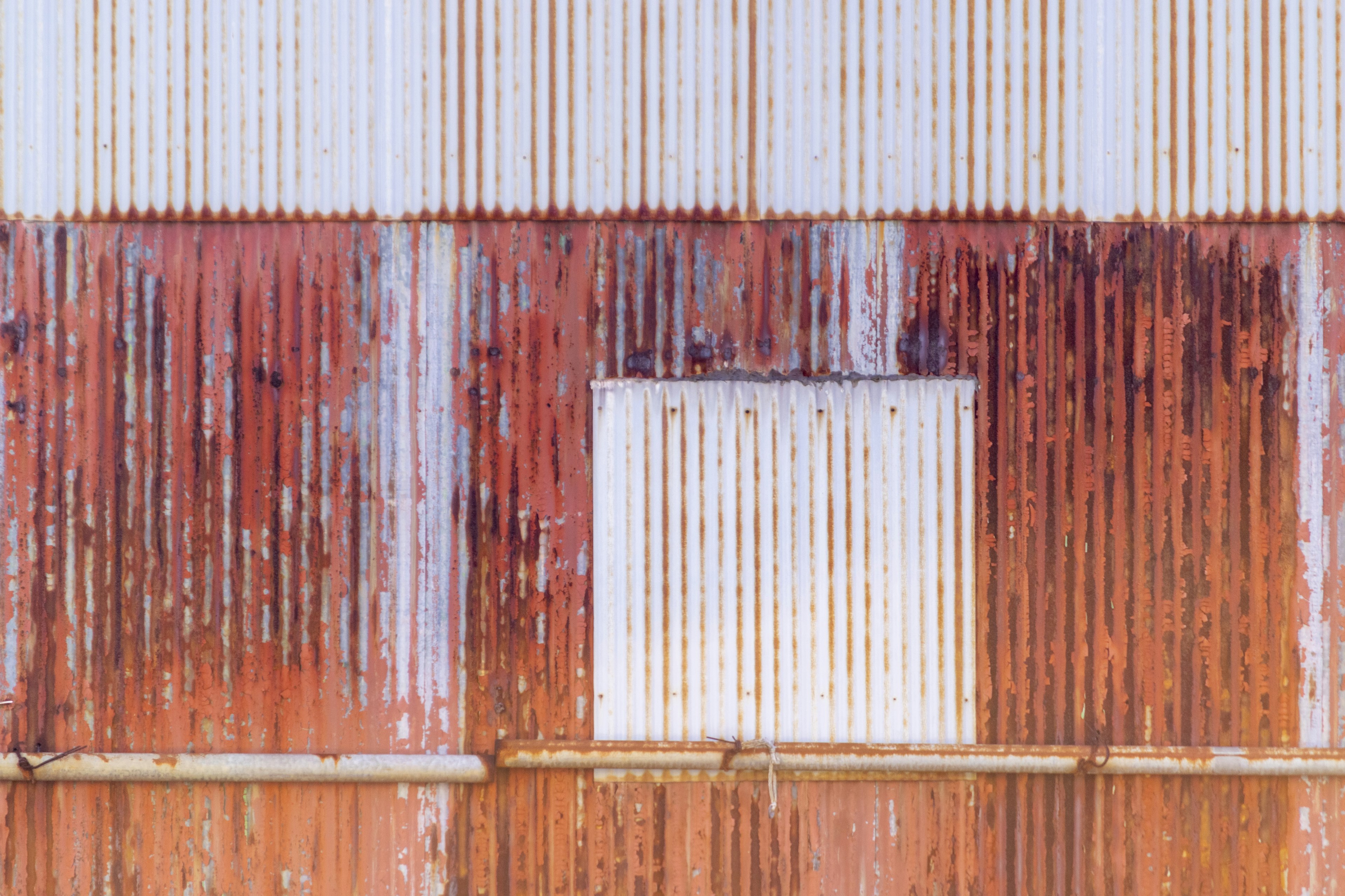 Textured metal wall with rust and white stripes