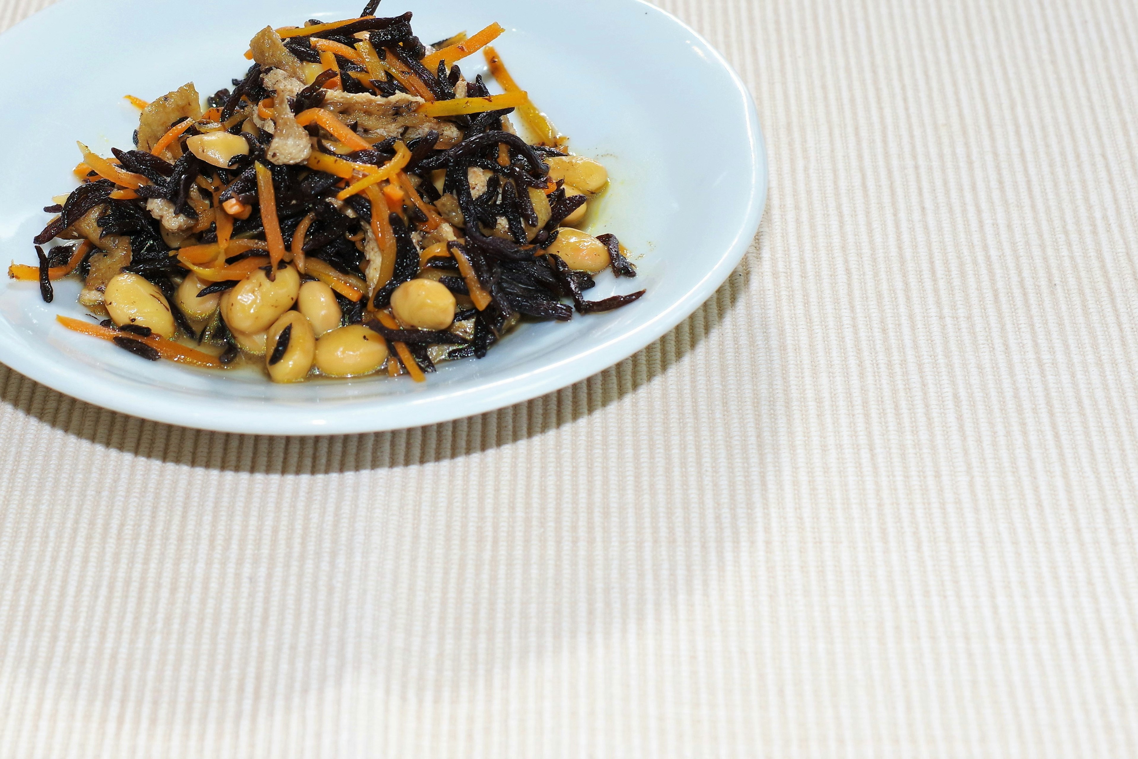 Salad of hijiki seaweed and beans served in a white bowl