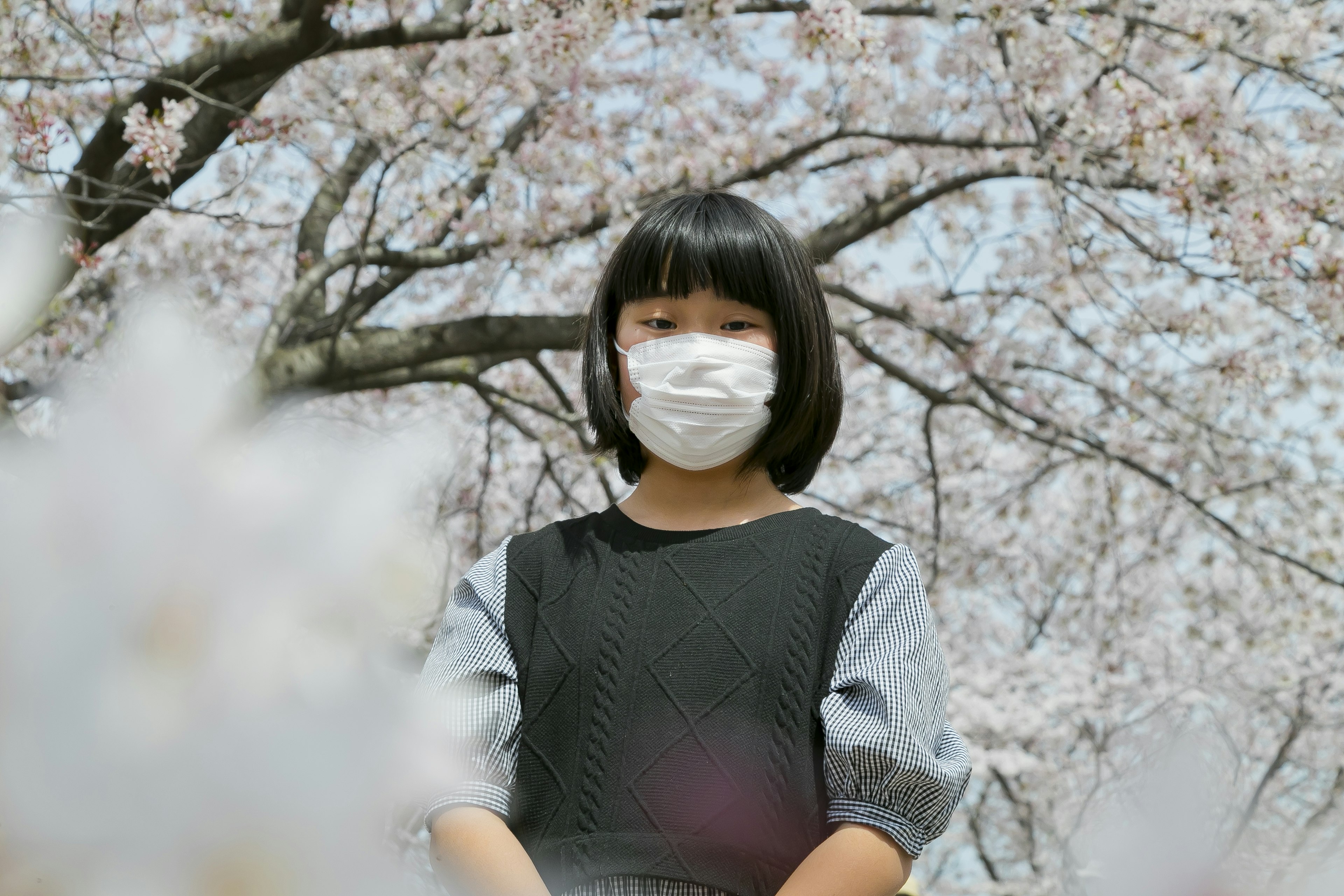 Mädchen mit Maske unter einem Kirschbaum