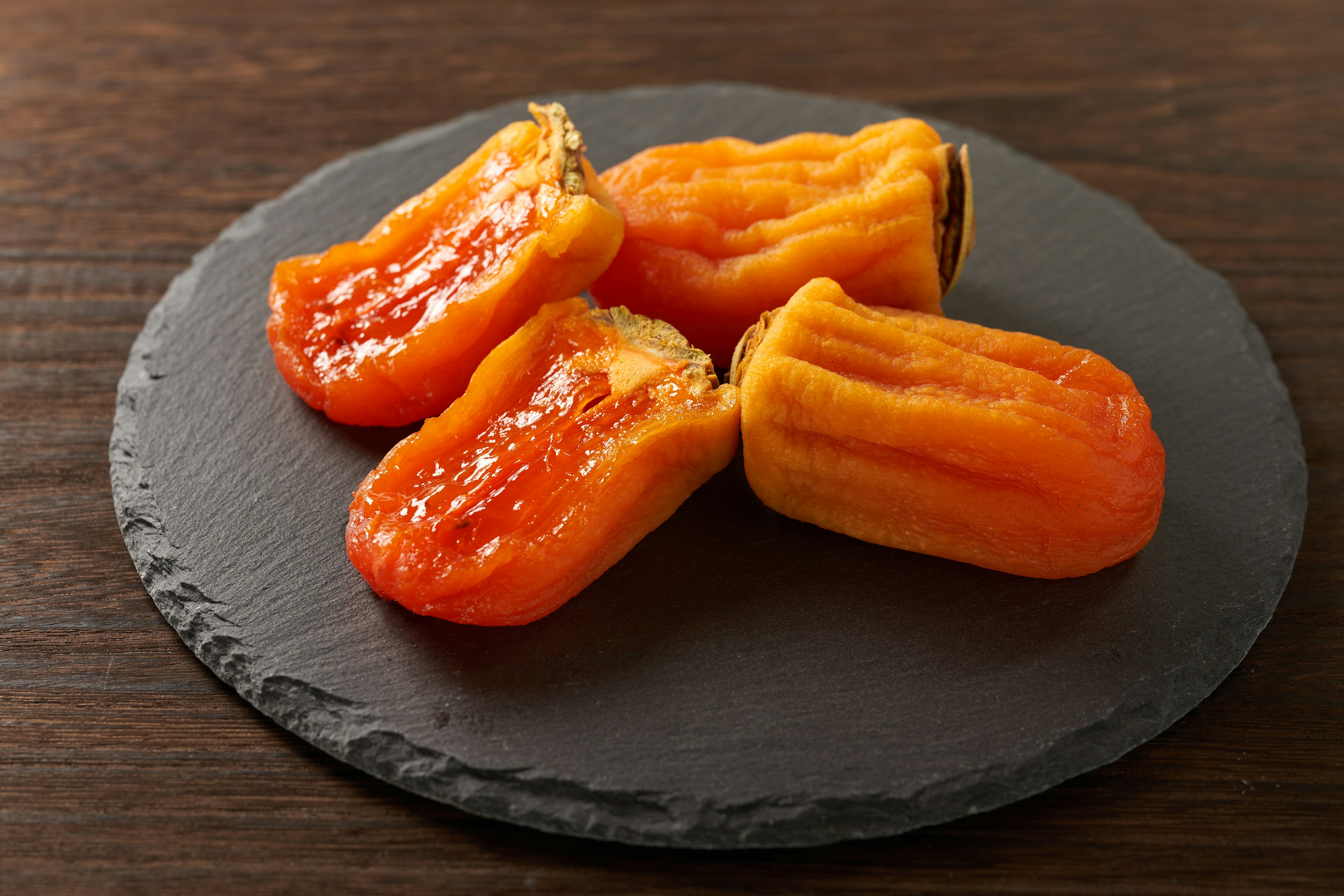 Orange sweets placed on a black plate