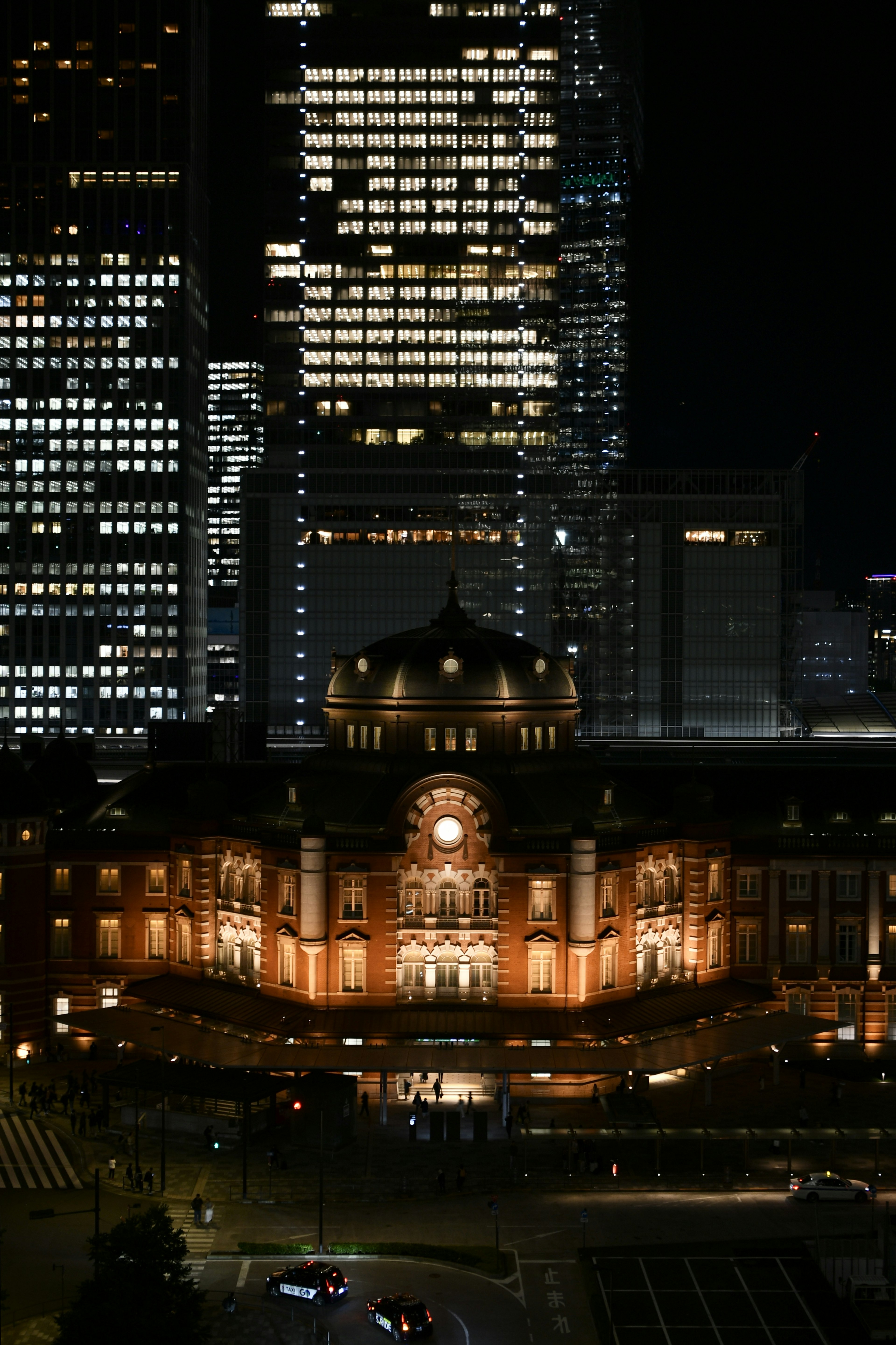 Tokyo Station at night with modern skyscrapers