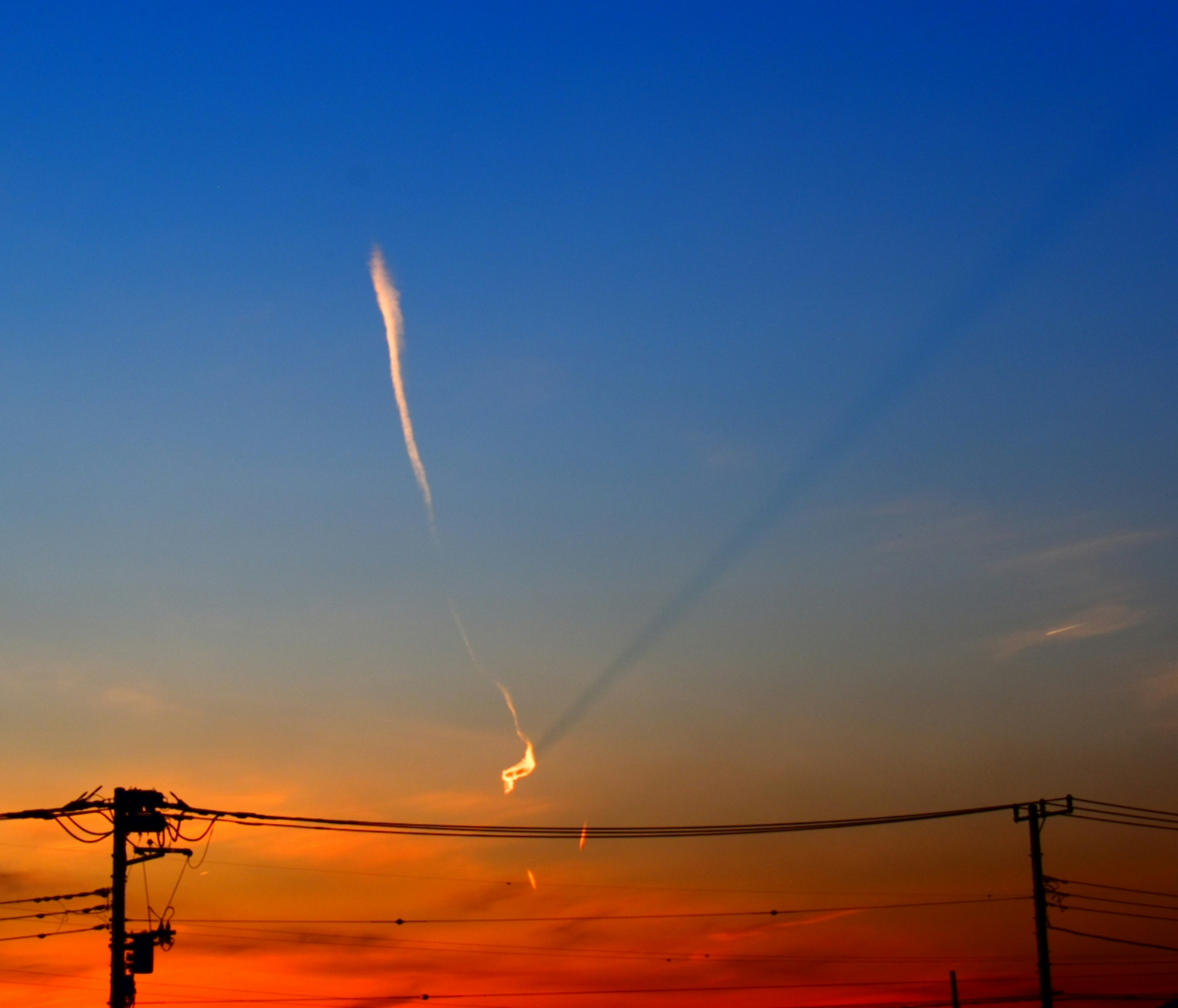 Cielo al tramonto con nuvole sottili e linee elettriche