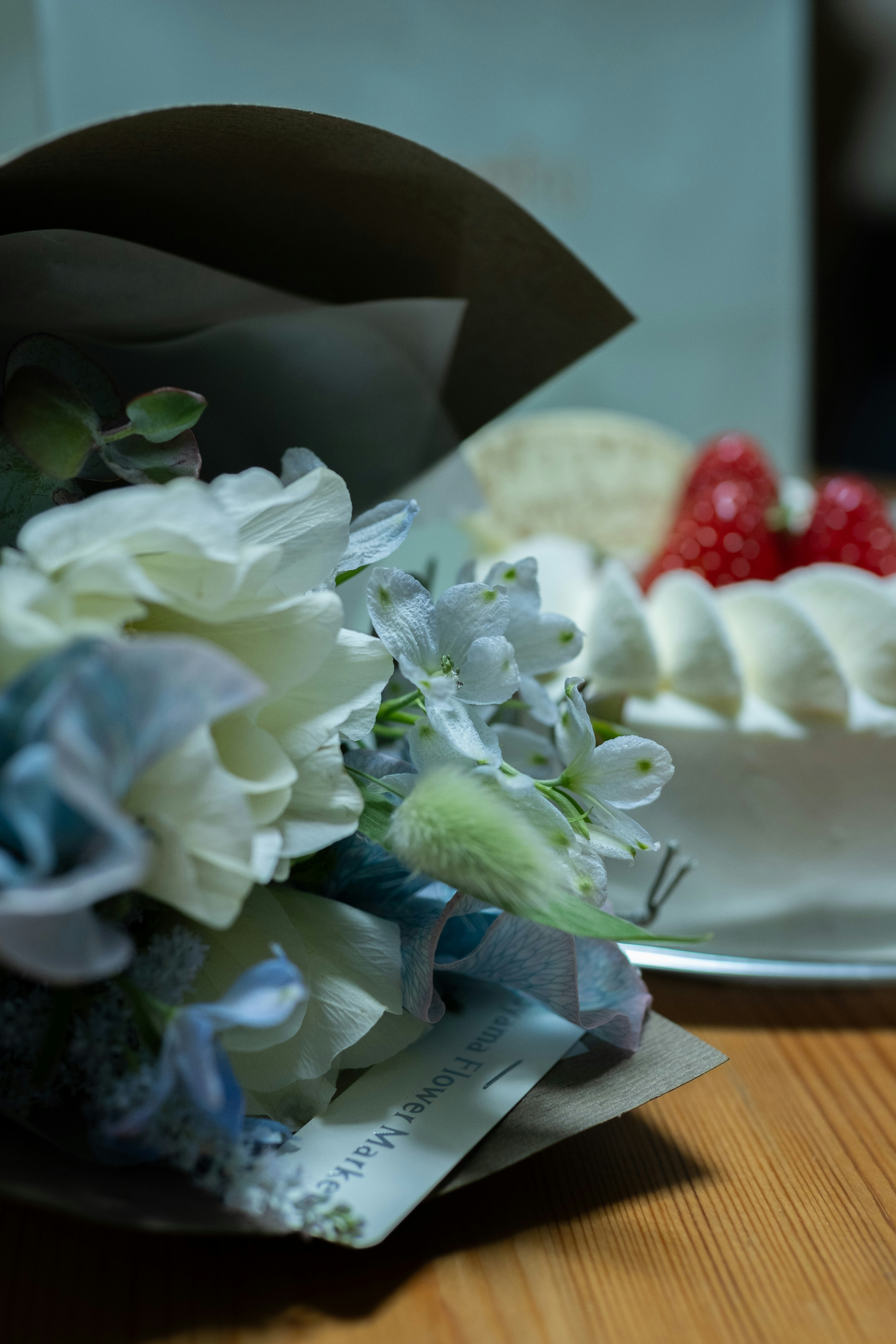 Bouquet de fleurs blanches et bleues à côté d'un dessert à la crème