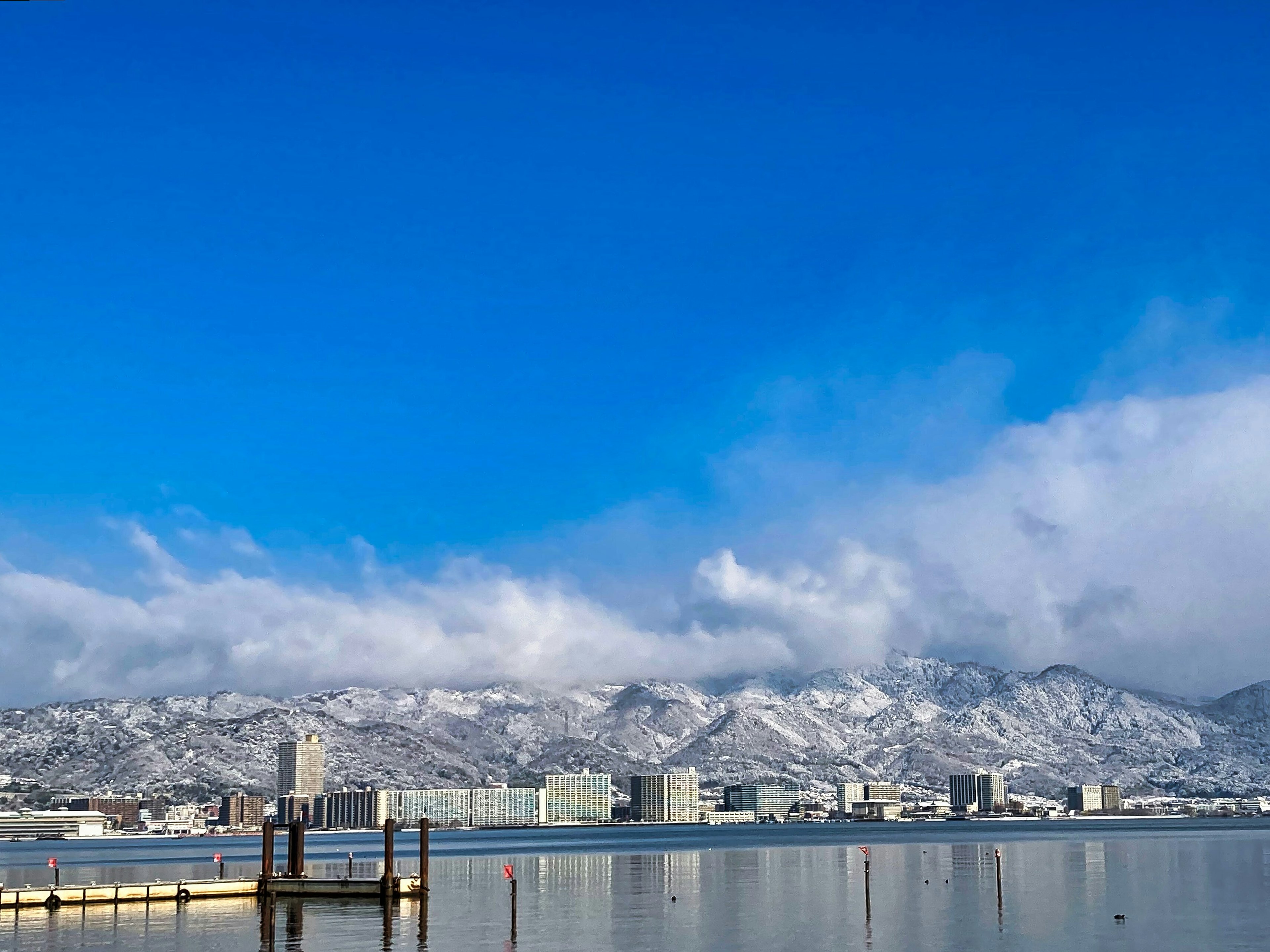 雪に覆われた山々と青空の下の静かな湖