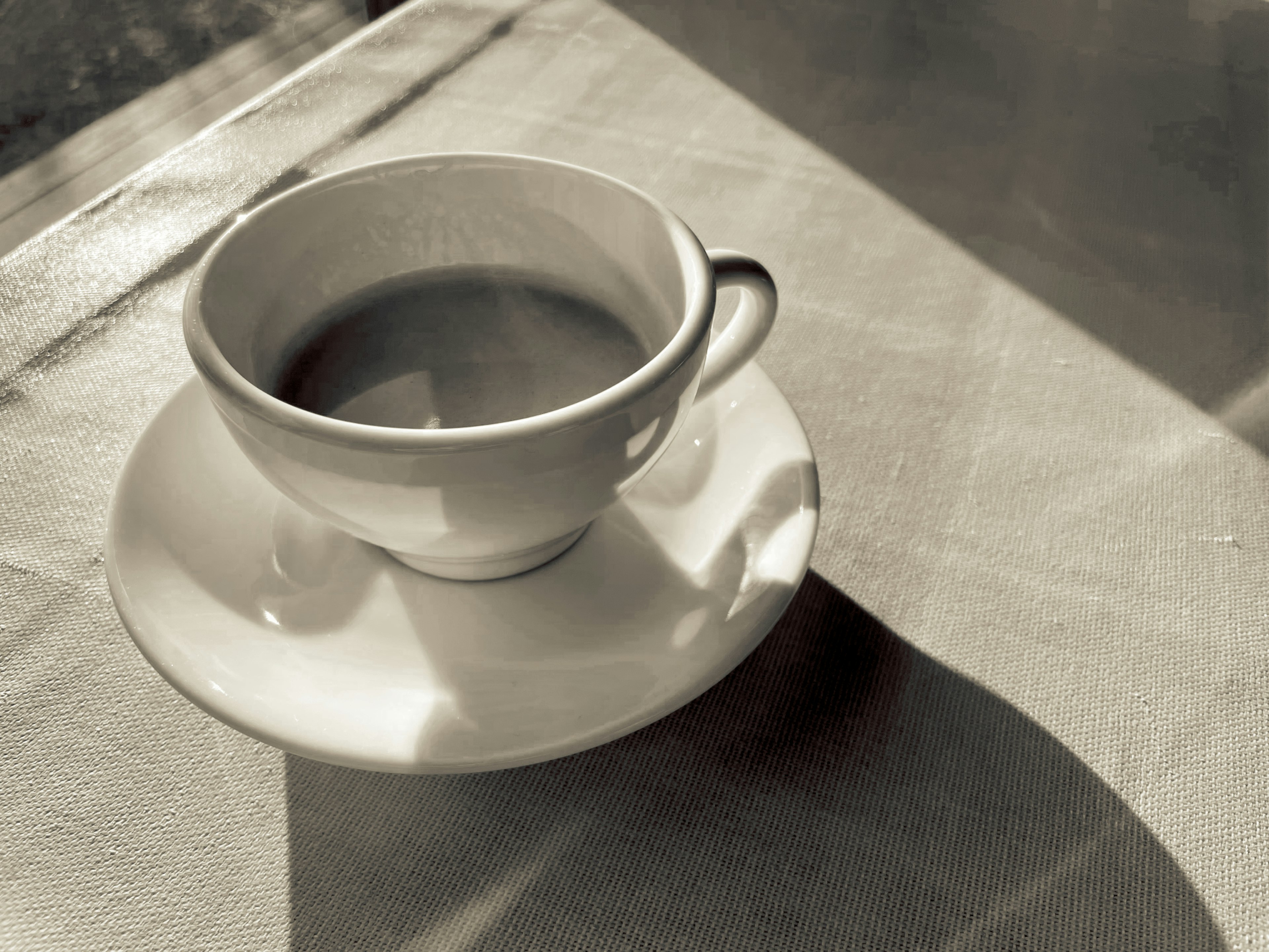 A white coffee cup and saucer placed on a table