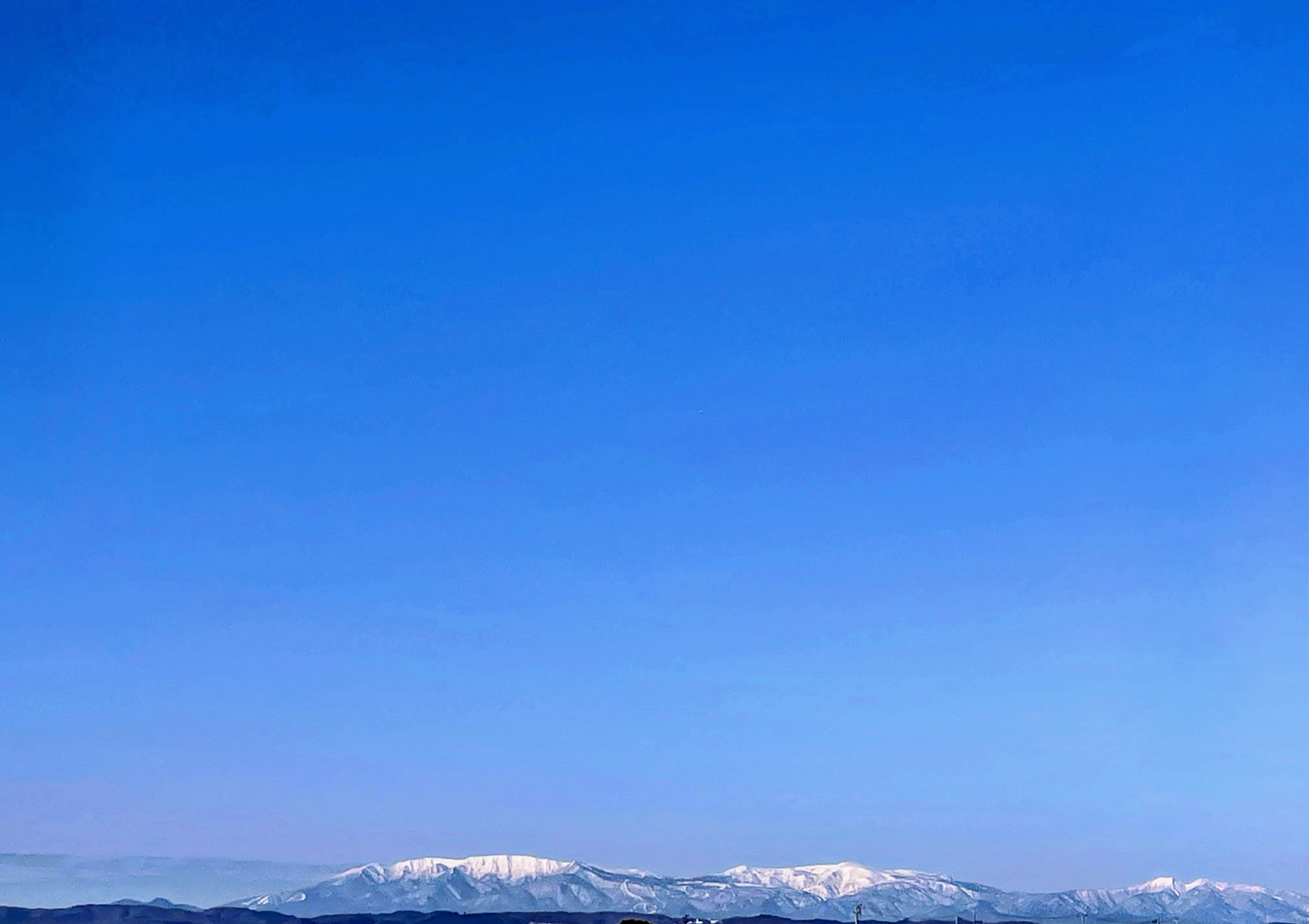 青い空と雪をかぶった山々の風景