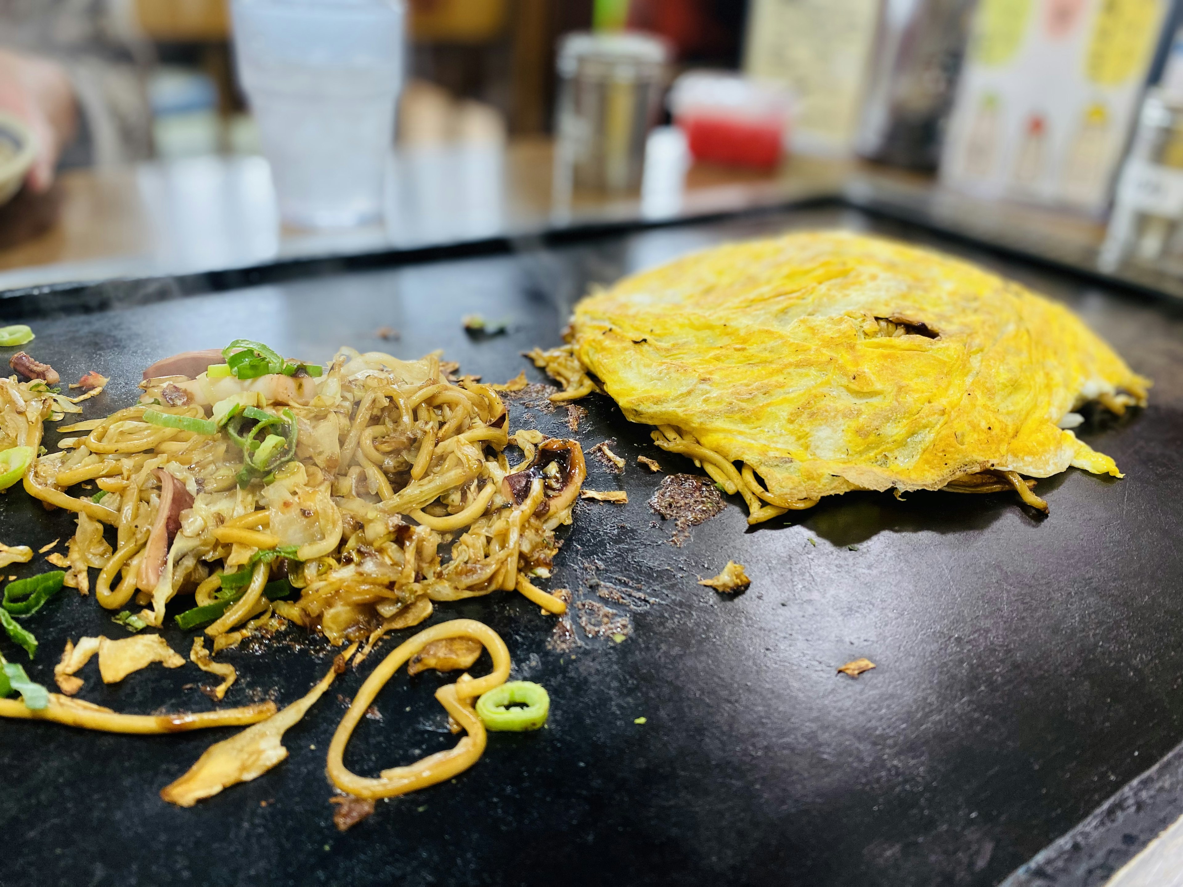 テーブルの上にある焼きそばとオムレツの皿