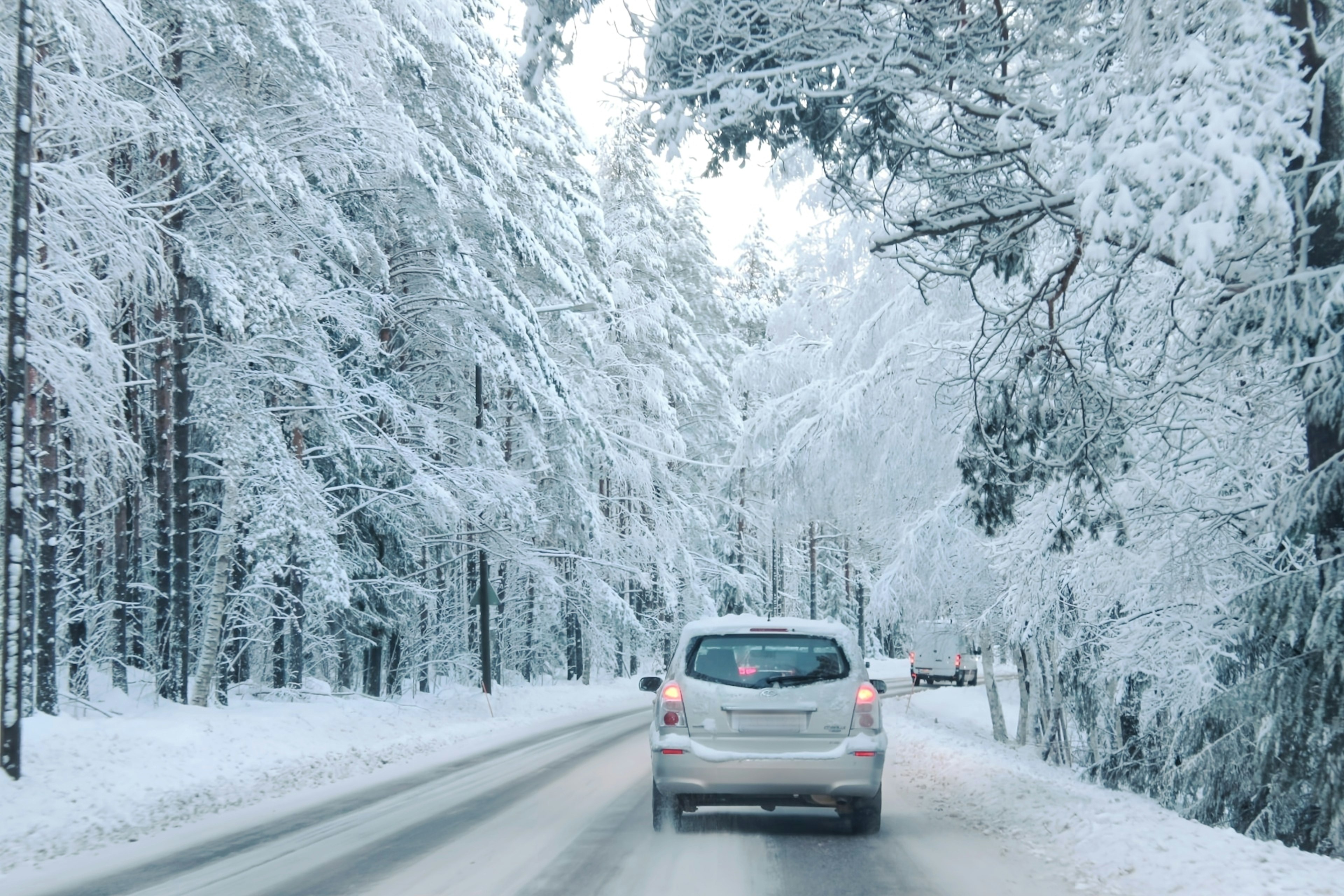 Auto fährt durch einen verschneiten Wald