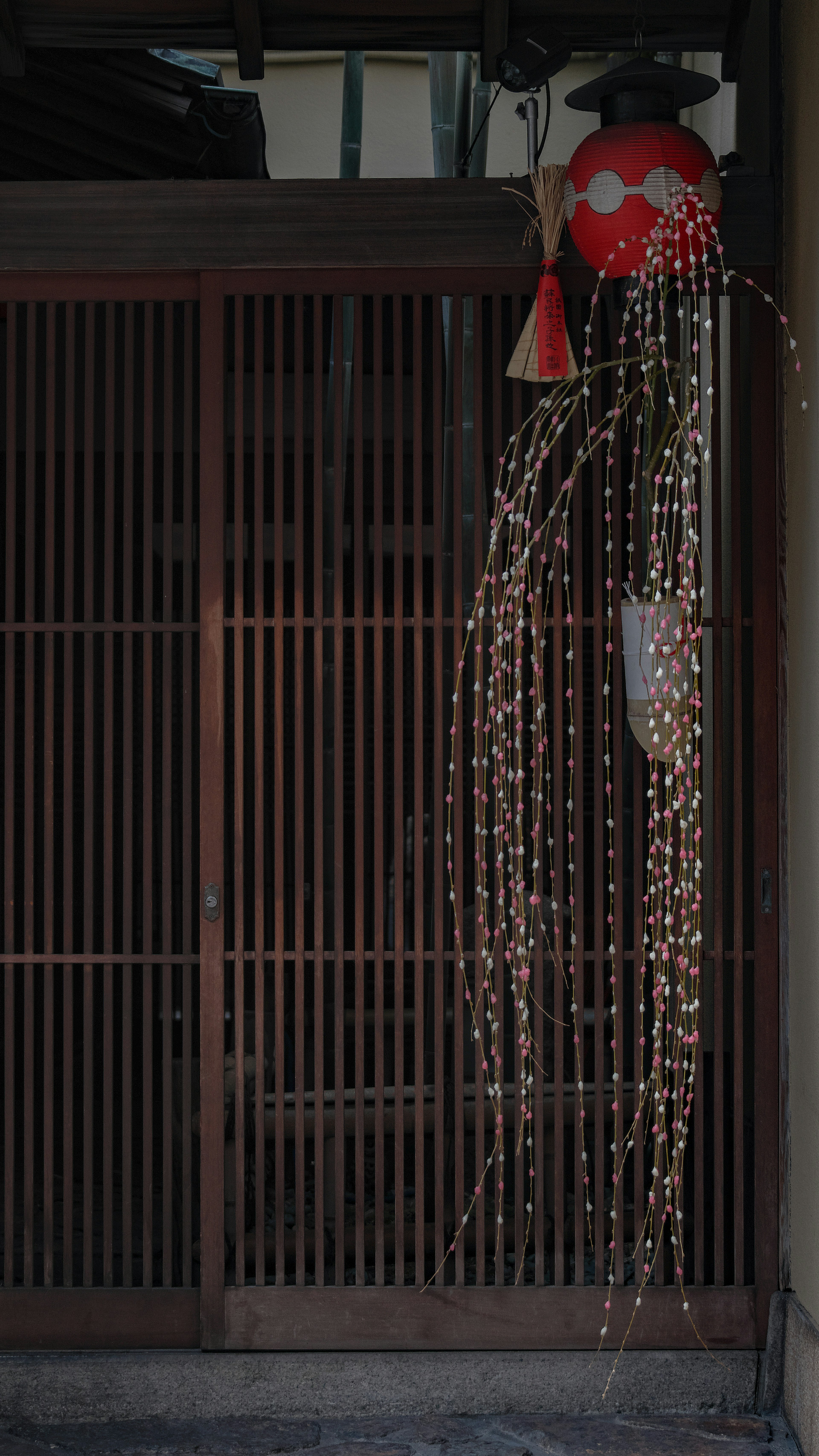 Décoration d'entrée japonaise traditionnelle avec un ornement rouge et des fils décoratifs longs