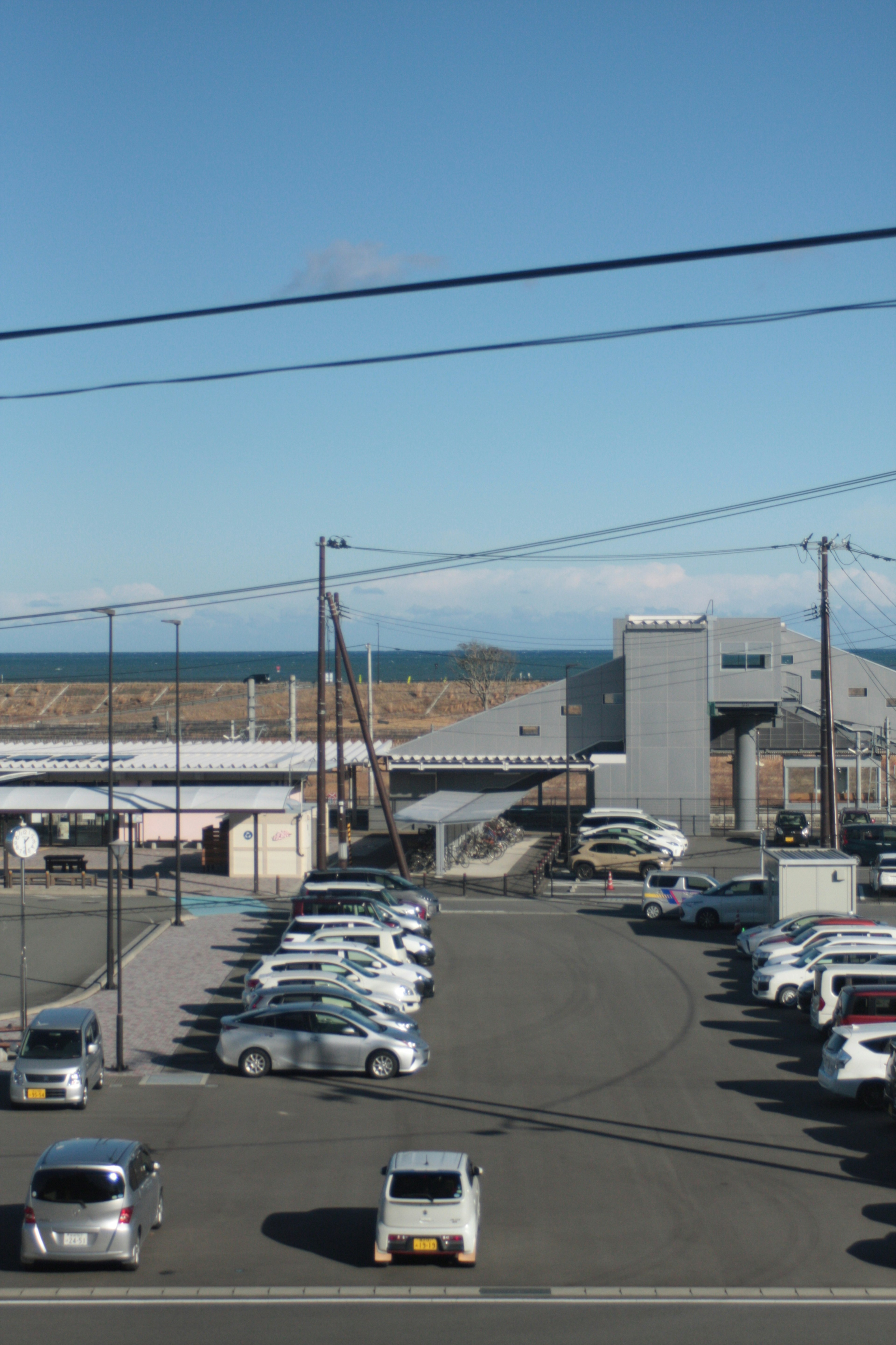 Parking lot with clear blue sky ocean visible in the distance