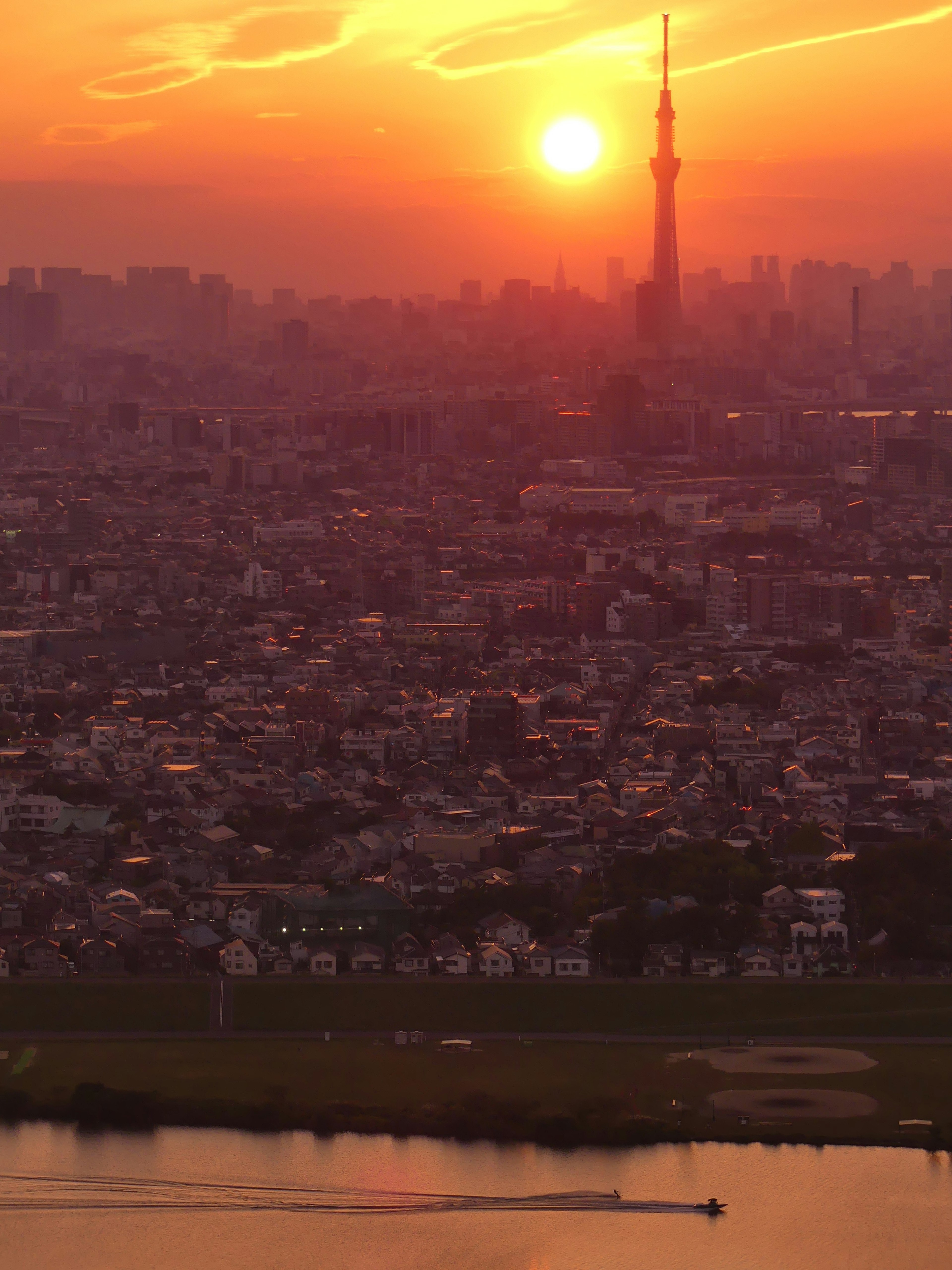 Tokyo Skytree silhouettiert vor einem lebhaften Sonnenuntergang über der Stadt