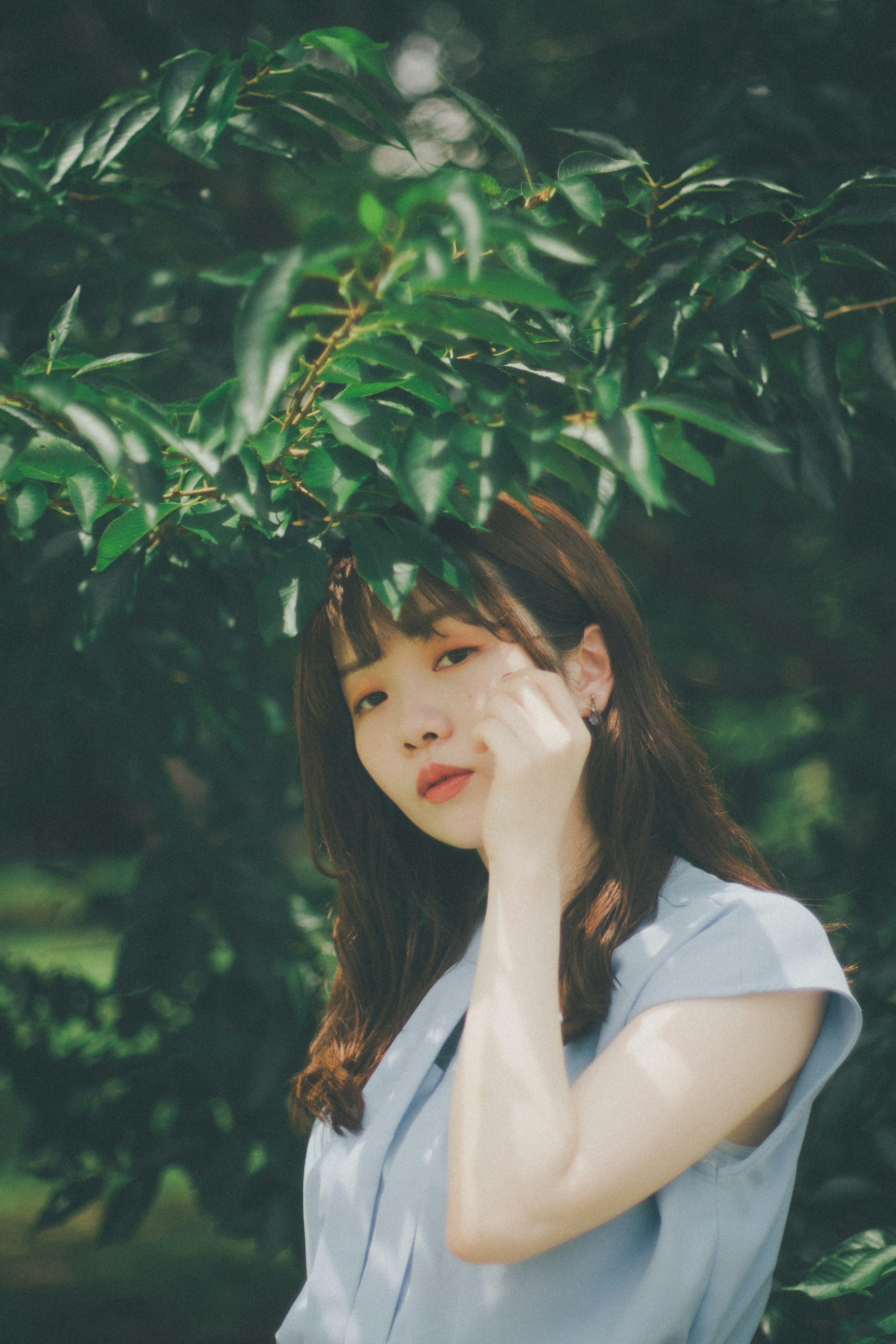 Portrait d'une femme se tenant parmi des feuilles vertes