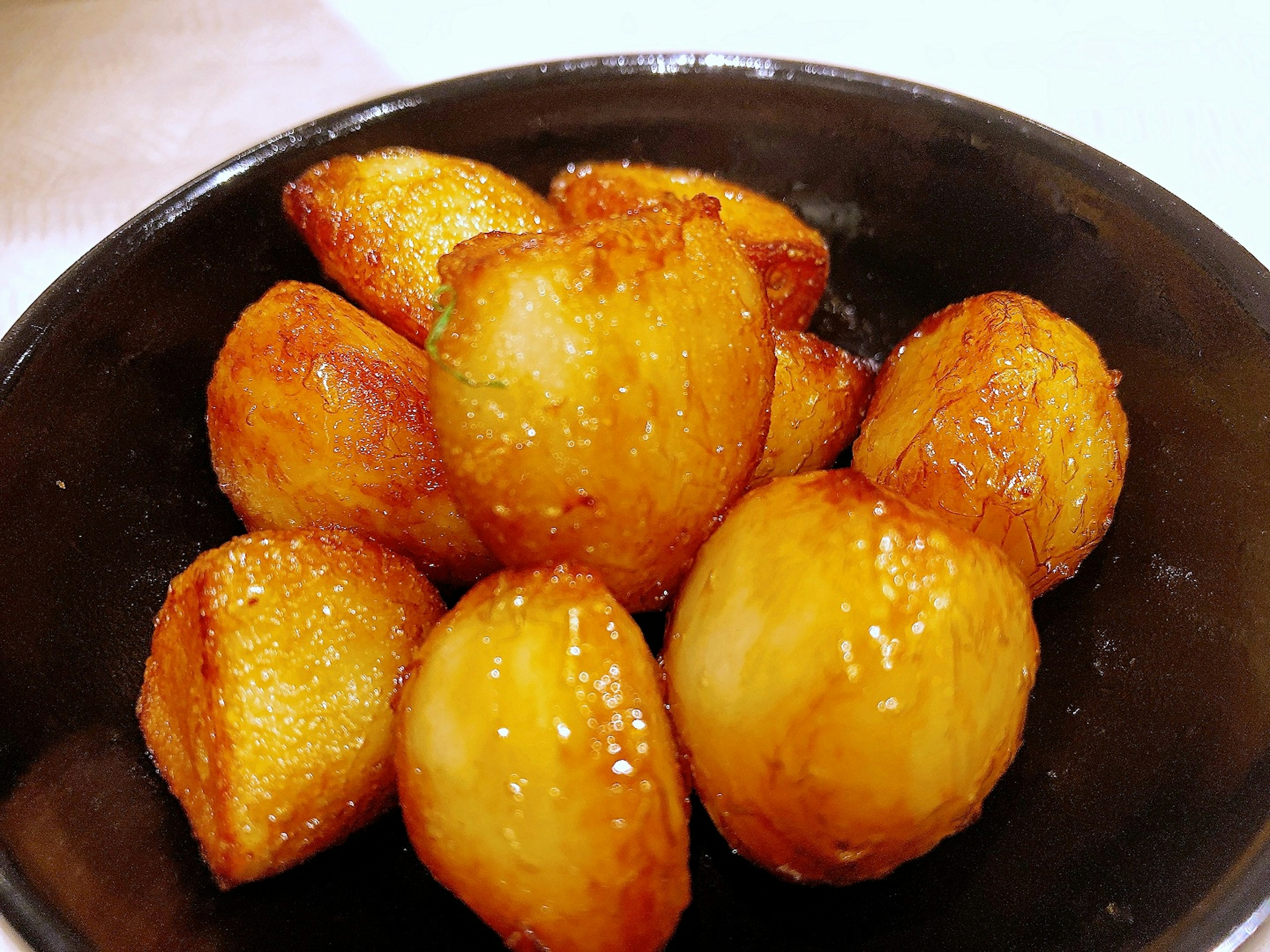 A mound of golden fried pastries on a black plate