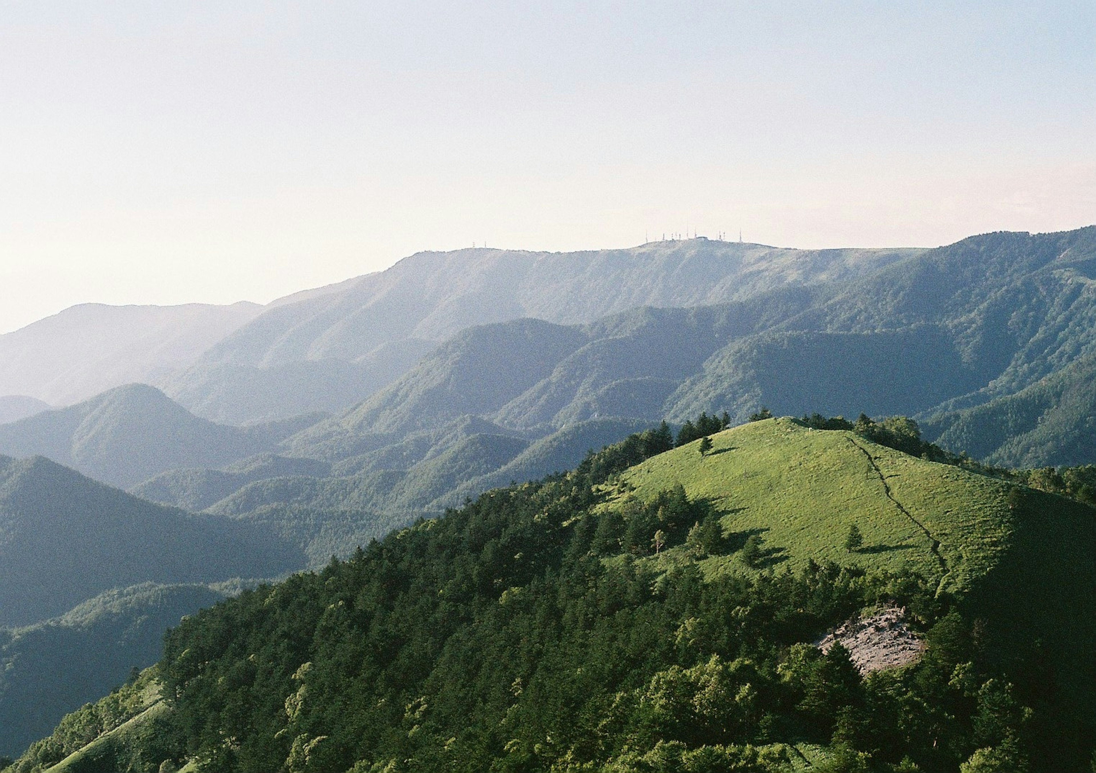 Pemandangan panorama pegunungan hijau dan bukit bergelombang