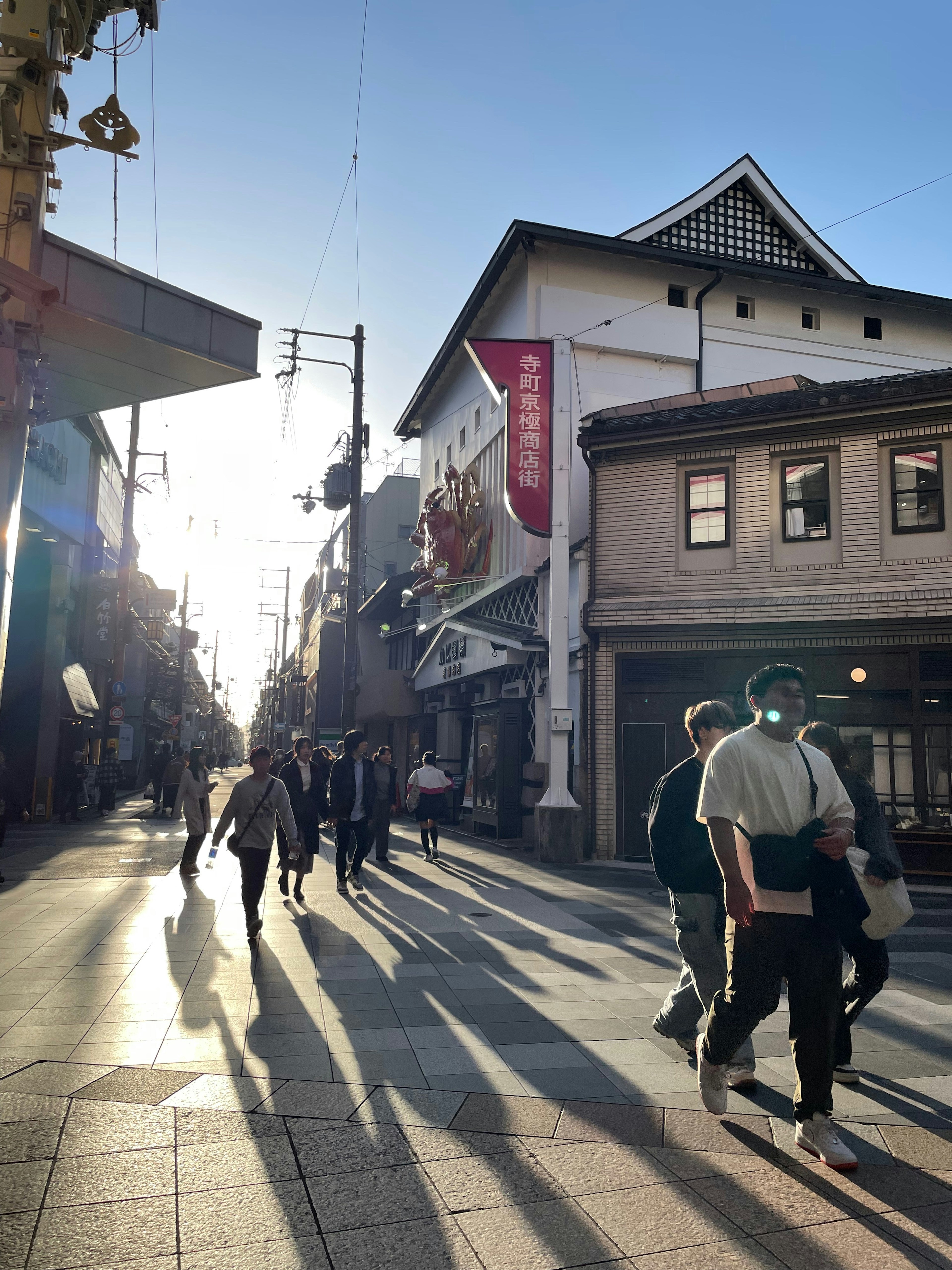 People walking in a shopping street during sunset