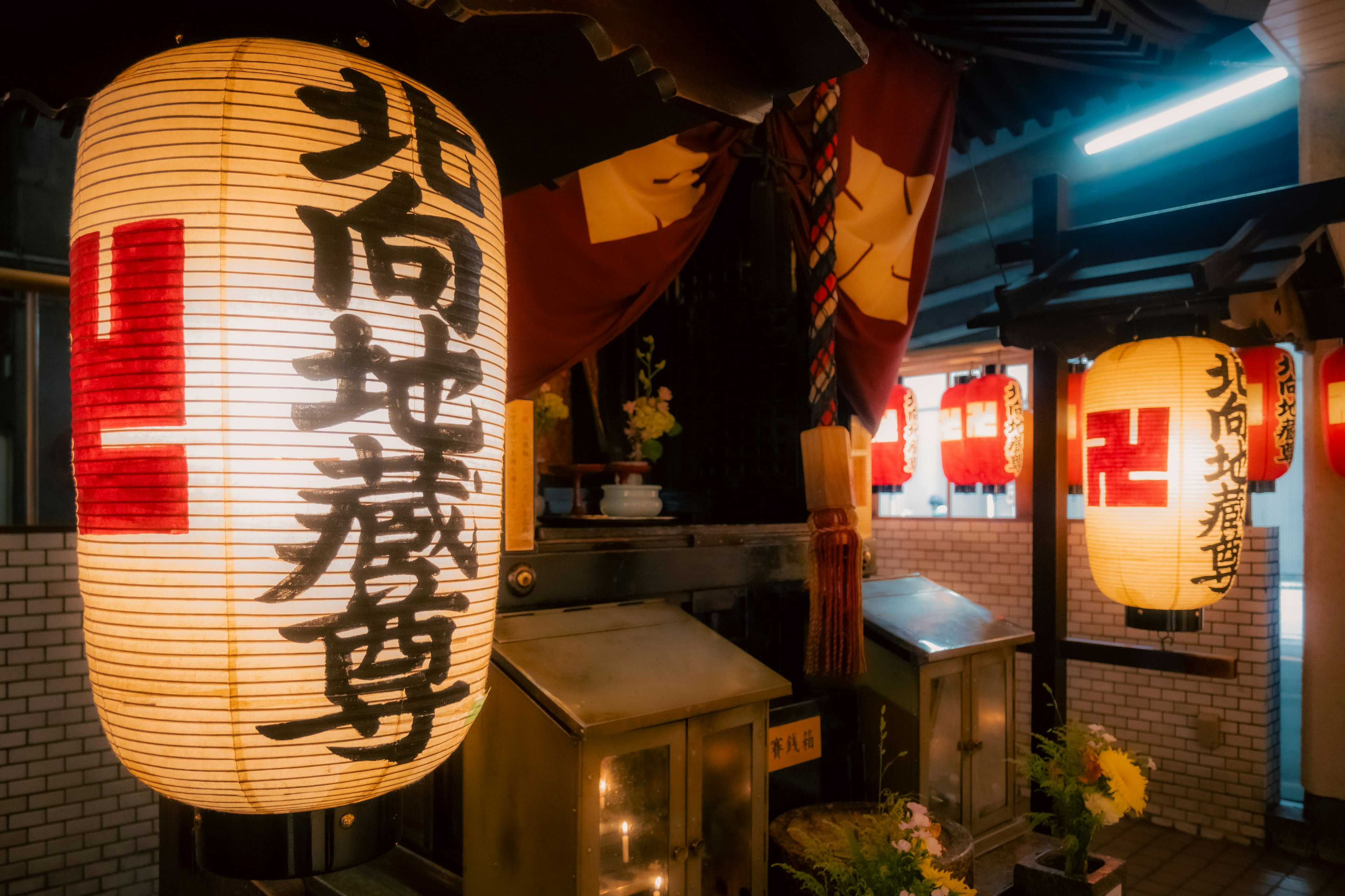 Illuminated lanterns and decorative flags in a nighttime street scene