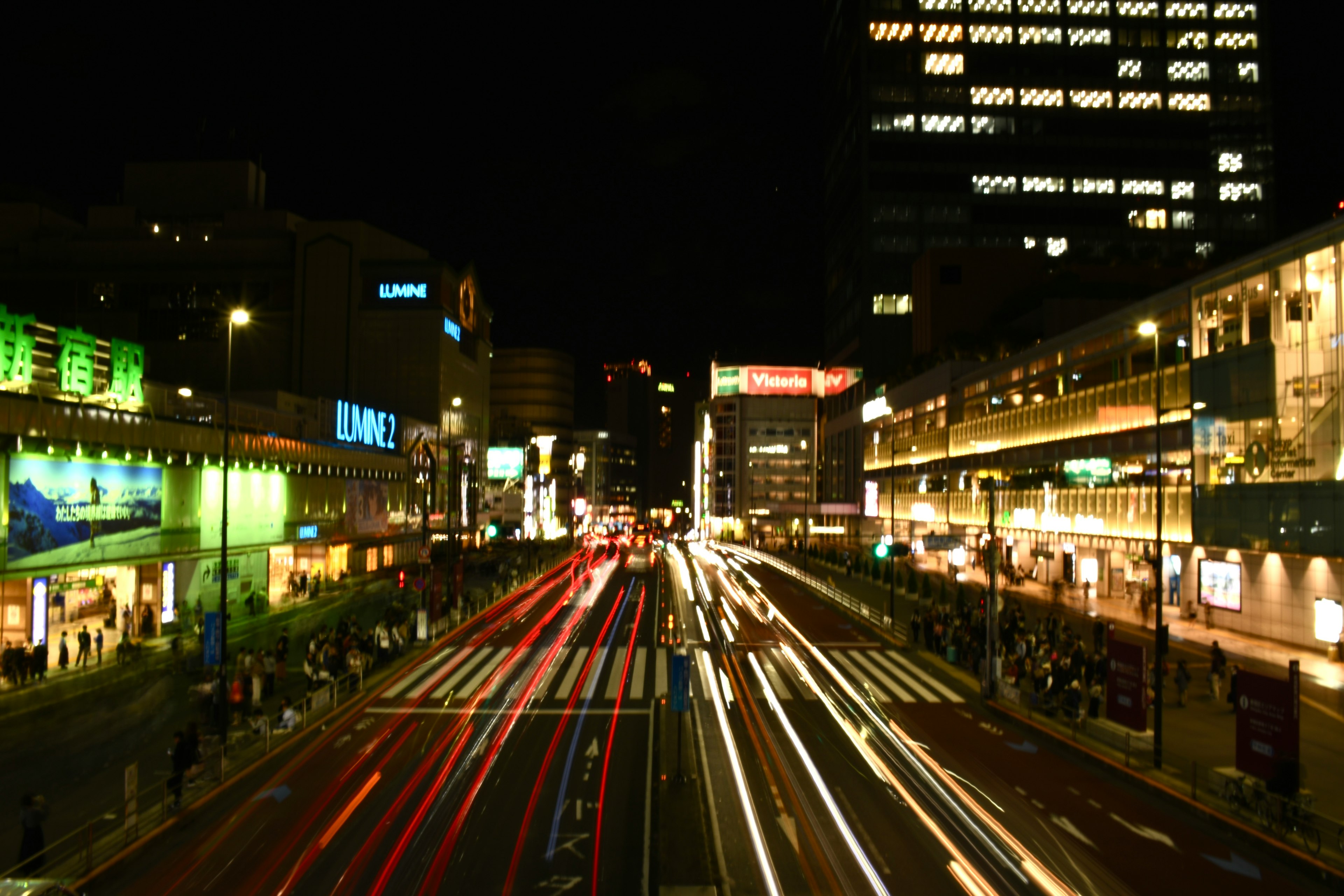 夜の都市の交差点を映した写真車のライトが流れるように見える