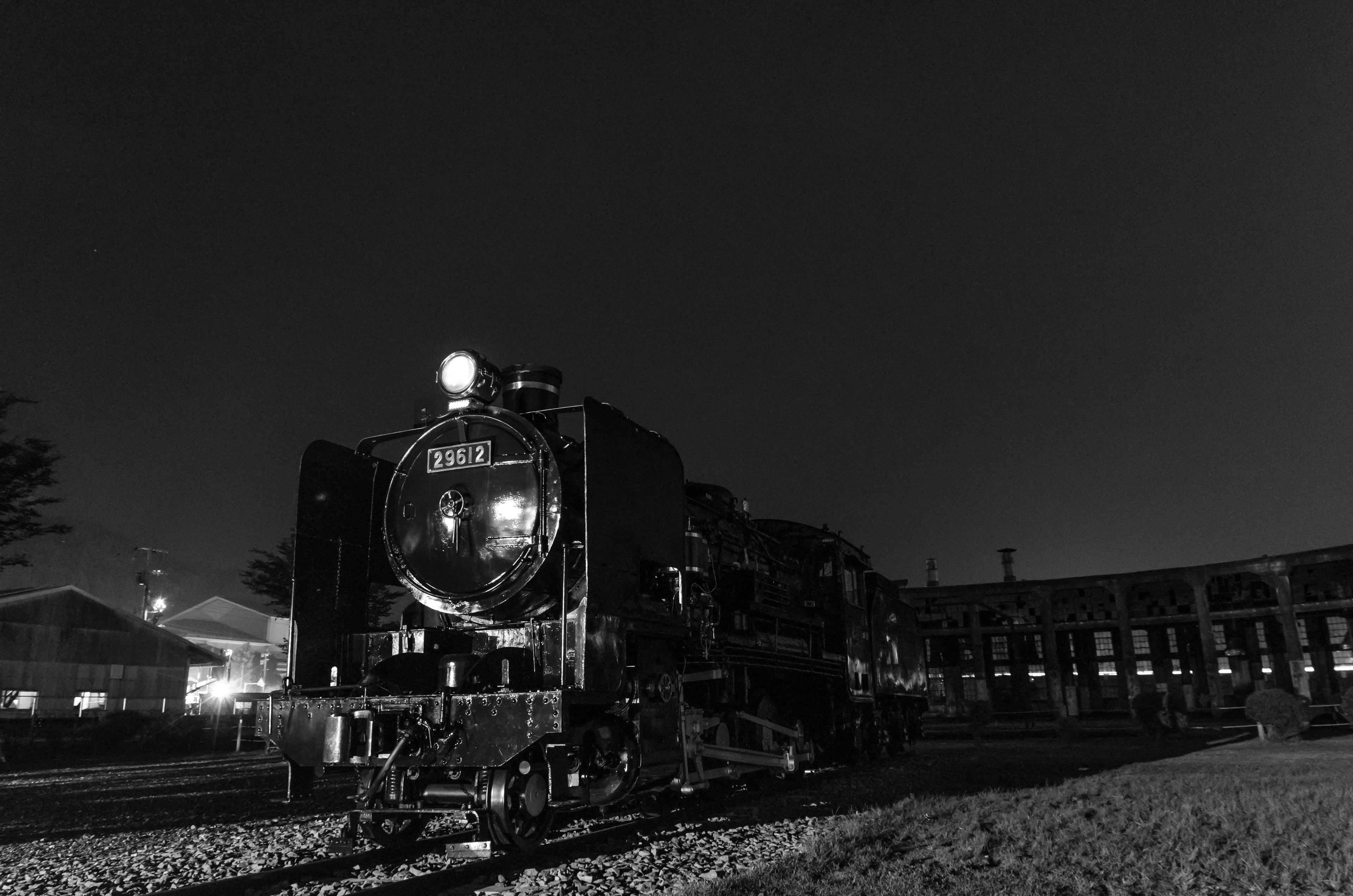 Foto in bianco e nero di una locomotiva a vapore di notte che mostra la storia ferroviaria