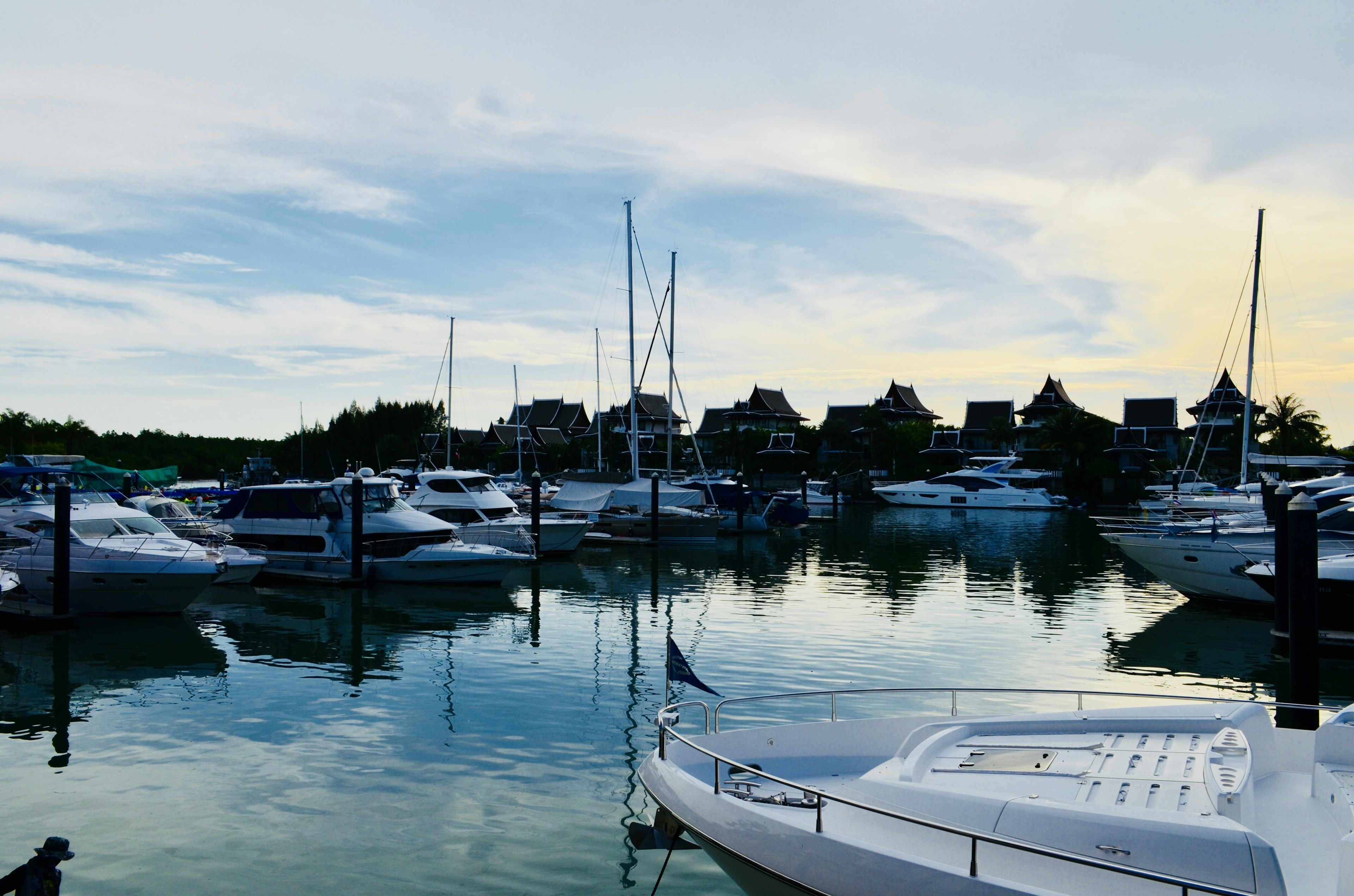 Serene marina scene with white boats and reflections of surrounding buildings