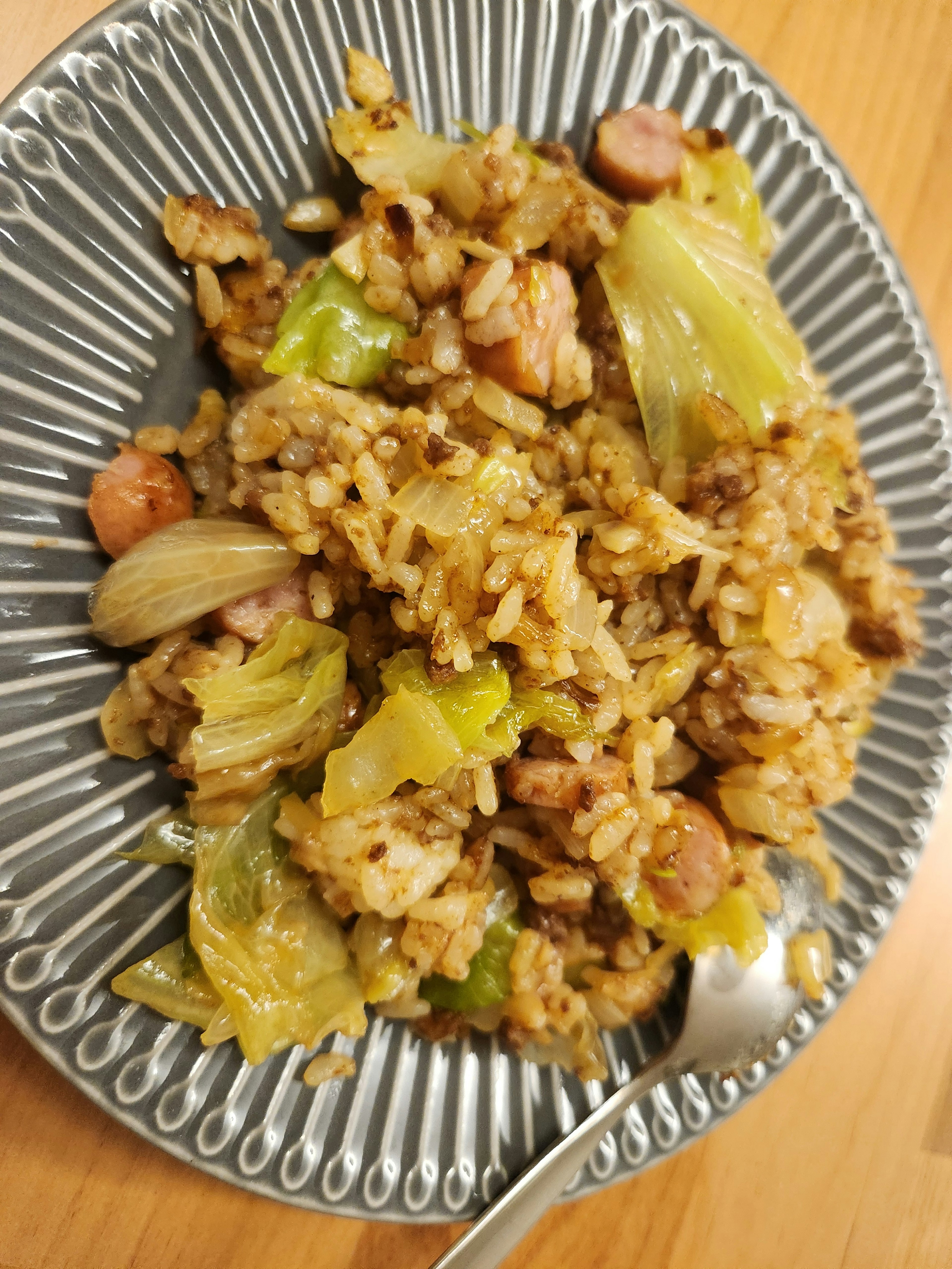 Arroz salteado con repollo y salchichas en un plato decorativo